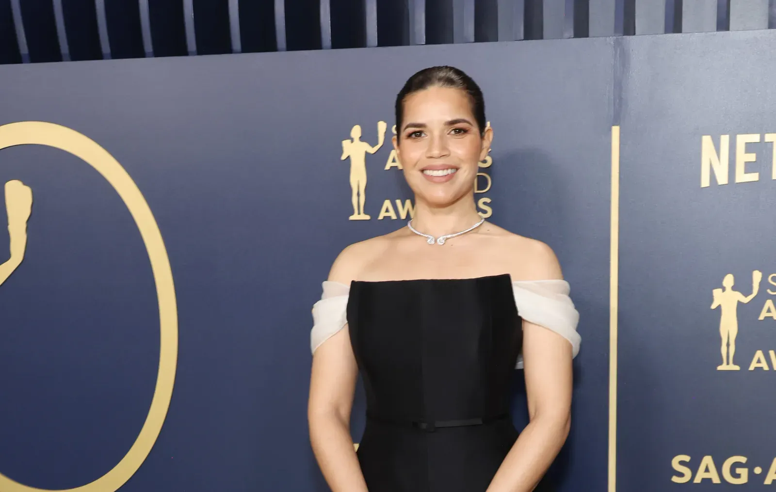 America Ferrera smiling confidently in a black Dior Haute Couture dress at the 30th Annual Screen Actors Guild Awards.