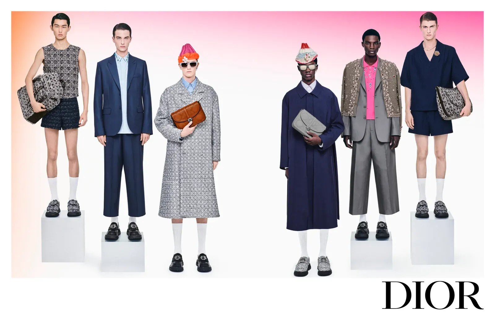 A group of five male models showcasing an array of DIOR men's fashion SS24, featuring a mix of casual and formal wear, accessorized with various bags, and standing against a pink gradient background with the DIOR logo below.