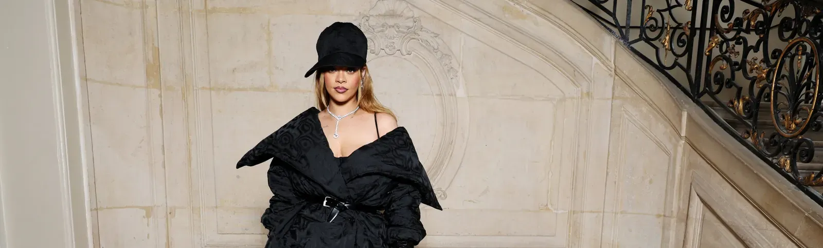 Rihanna wearing a stylish black outfit at the Dior Spring Summer 2024 Haute Couture show.
