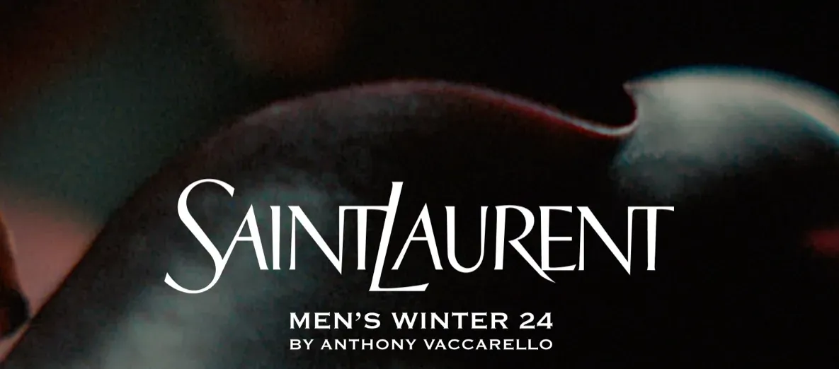 Promotional banner for Saint Laurent's Men's Winter 2024 collection by Anthony Vaccarello, featuring the brand's iconic logo in white over a dark, abstract background.
