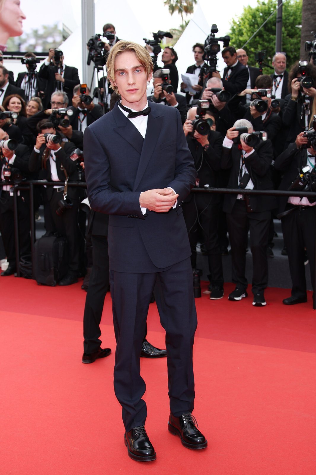 Levon Roan Thurman-Hawke is dressed in Dior by Kim Jones. Levon Hawke wore a midnight blue wool peak lapel Oblique tuxedo, a white cotton wing-tip collar shirt, a midnight blue silk bow-tie and black leather Carlo derbies.