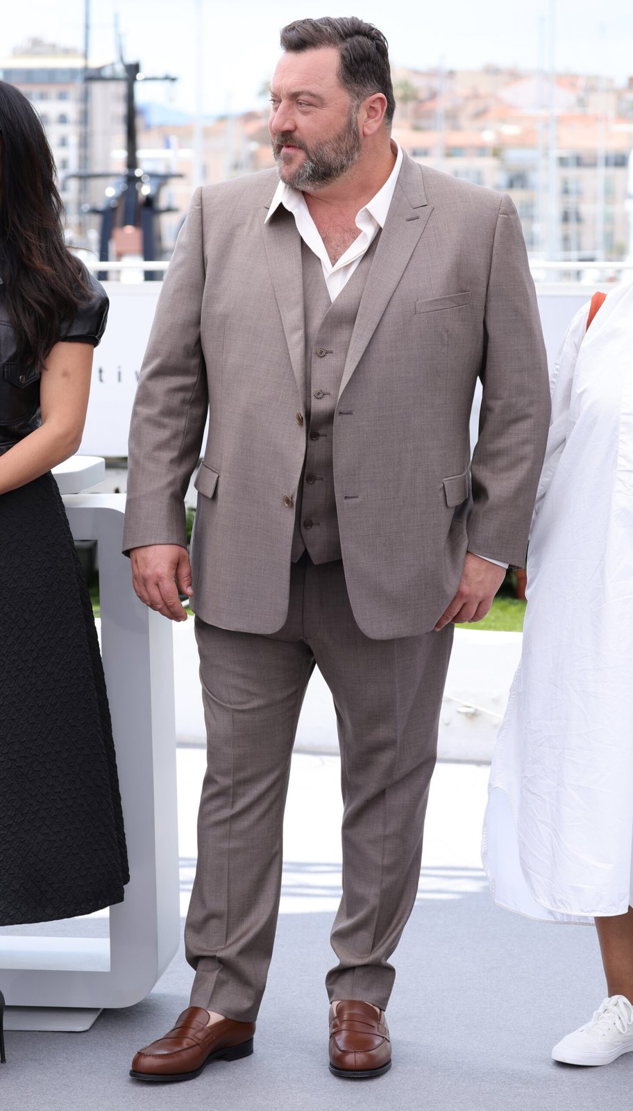 Jury member Denis Ménochet is dressed in Dior by Kim Jones. Make up by Dior. Denis Ménochet wore a made-to-measure brown wool peak lapel suit with a matching vest and a classic white cotton shirt.