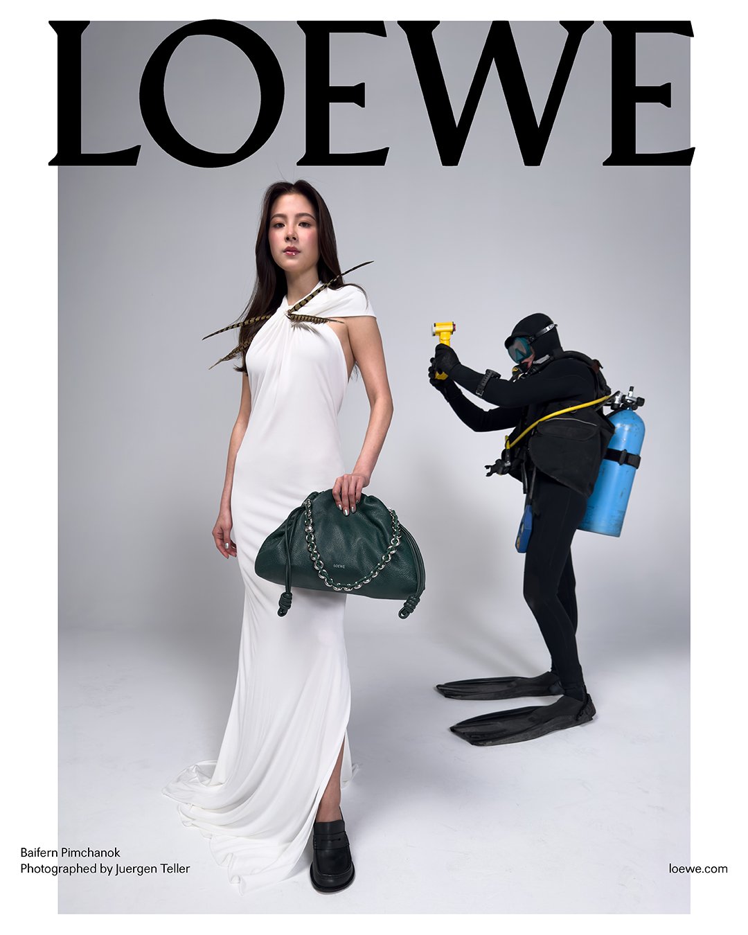 Baifern Pimchanok in a white gathered-neck gown with the LOEWE Luna bag in forest green, accompanied by a scuba diver for the LOEWE Spring-Summer 2025 campaign (Photography: Juergen Teller)