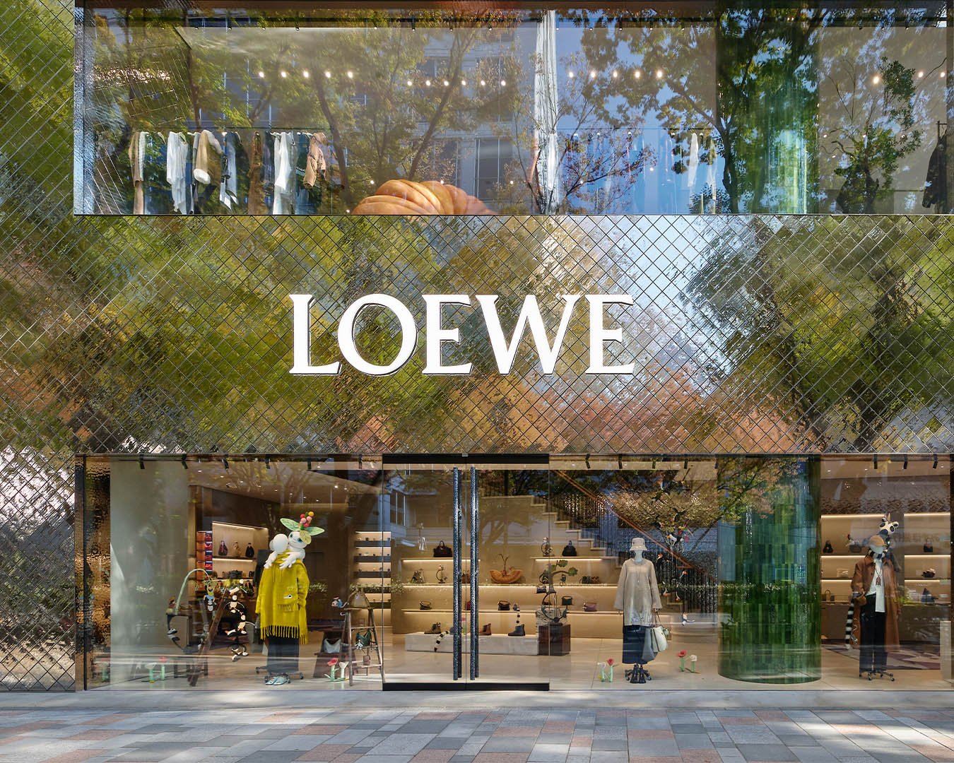 Reflective Grandeur: The reflective façade of CASA LOEWE Omotesando mirrors the bustling street of Tokyo, inviting passersby into a world where luxury and artistic expression coalesce.