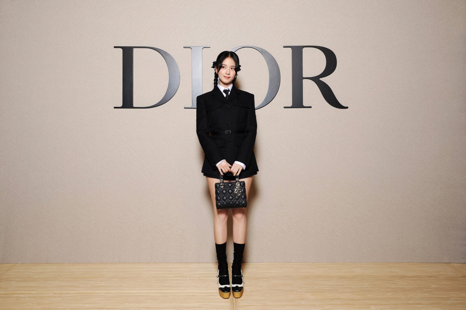 Jisoo of BLACKPINK presents youthful radiance in a playful Dior short dress and blazer, accessorized with a patterned handbag and knee-high socks, redefining classic Parisian style. (Photo by Pascal Le Segretain/Getty Images for Christian Dior)