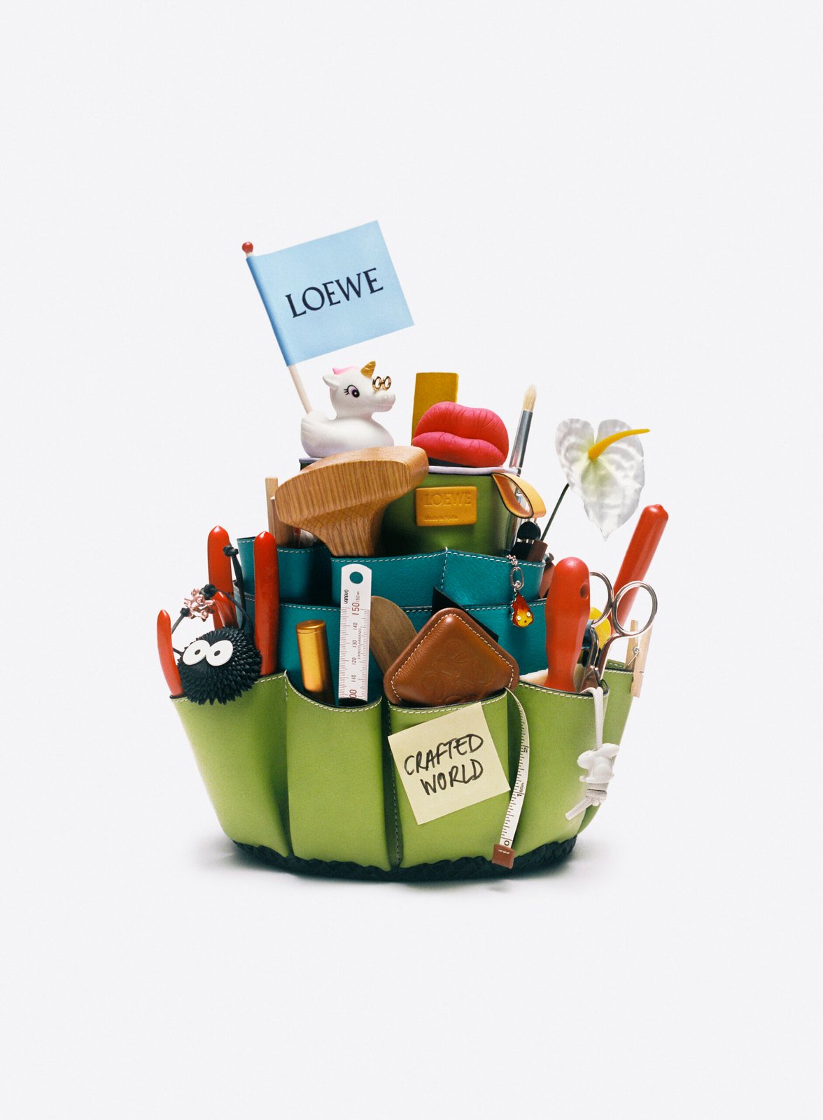 A whimsical LOEWE accessory holder brimming with playful items and the 'Crafted World' tag, indicative of their exhibition.