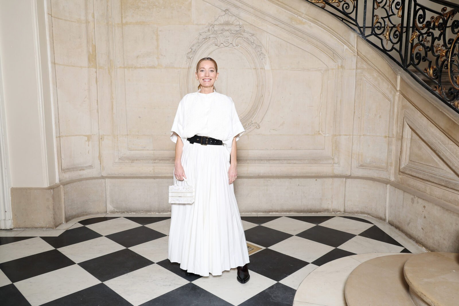 Lucie de la Falaise wore a Dior white cotton shirt decorated with embroidery and a pleated white silk skirt and a Dior belt, bag and shoes.