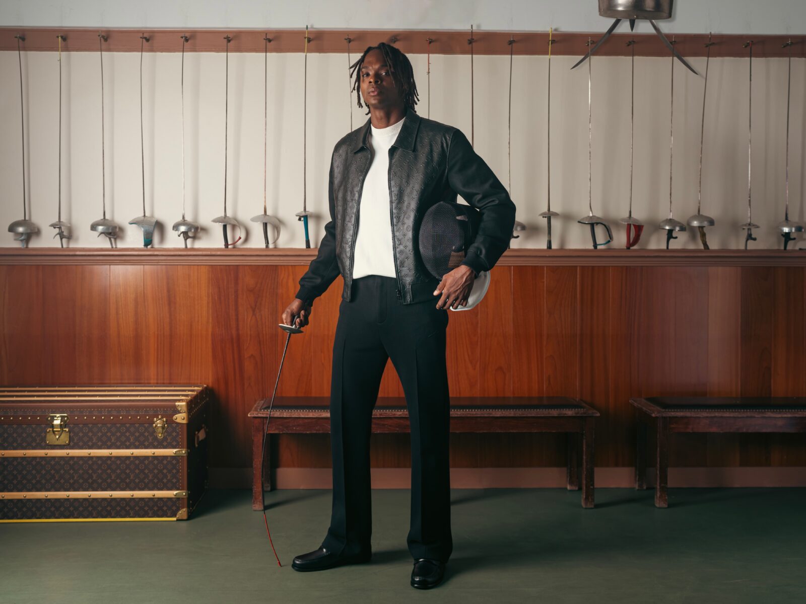 Enzo Lefort, seamlessly merging the world of fencing artistry with Louis Vuitton's iconic luxury, stands resplendent against a backdrop of gleaming foils and heritage trunks.
