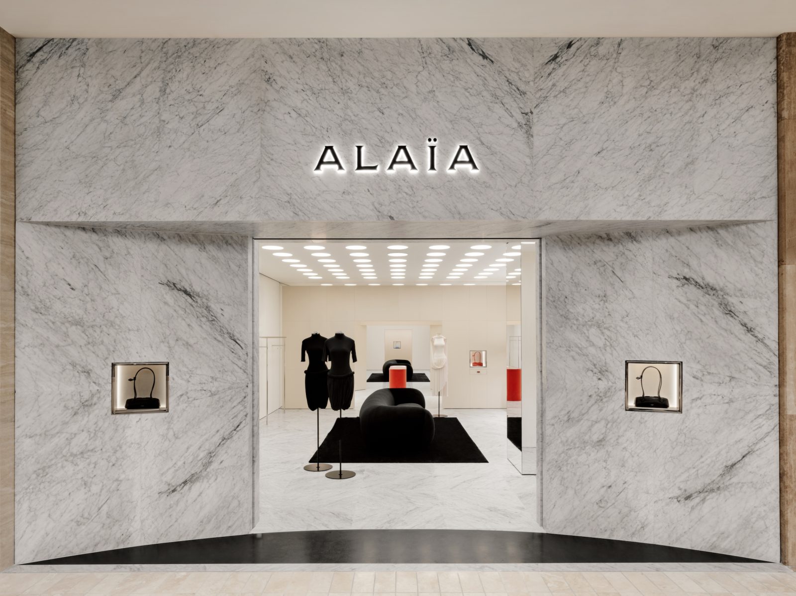 Interior view of the ALAÏA South Coast Plaza boutique, where Carrara marble walls and circular architectural elements create a gallery-like atmosphere for the Maison's sculptural collections. (Photos courtesy of ALAÏA)