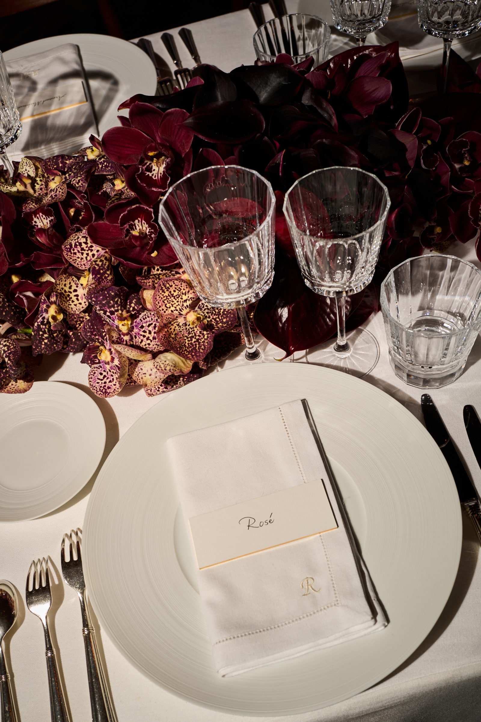 Rich burgundy orchids frame an elegant place setting at the Saint Laurent x Vanity Fair pre-Oscar dinner held in Mitch Glazer and Kelly Lynch's Hollywood Hills home. (Image courtesy of Saint Laurent) Rich burgundy orchids frame an elegant place setting at the Saint Laurent x Vanity Fair pre-Oscar dinner held in Mitch Glazer and Kelly Lynch