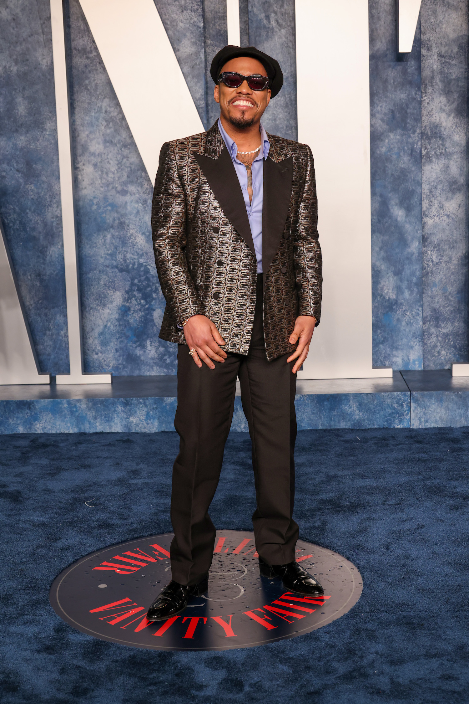 Anderson .Paak wore a custom Gucci gold and silver-patterned double-breasted tuxedo, white evening shirt, black bowtie, and black leather boots.