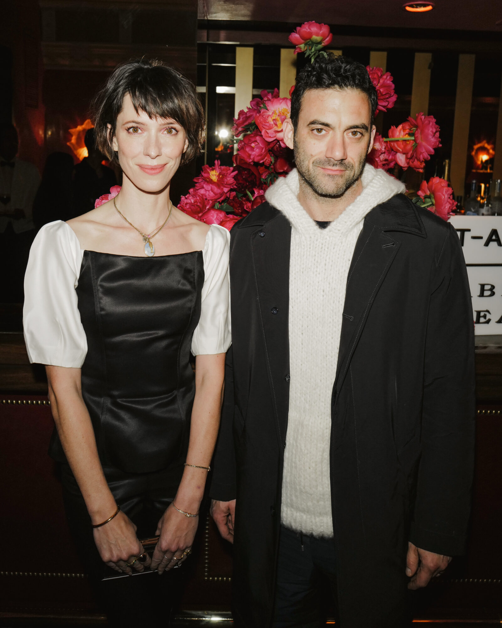 Rebecca Hall and Morgan Spector grace the Net-A-Porter event with understated elegance, complementing the vibrant floral backdrop. Images courtesy of BFA.