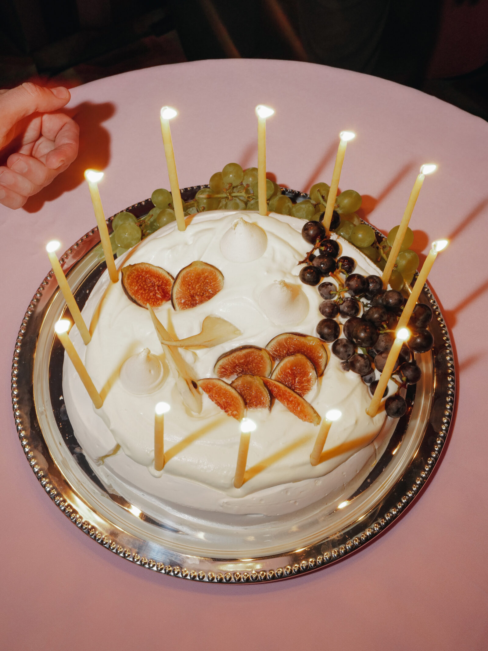 A decadent delight at the Net-A-Porter event: A luscious cake adorned with fresh figs and grapes, lit with slender candles to celebrate the fusion of fine taste and eco-conscious elegance inspired by Gabriela Hearst's designs. Images courtesy of BFA.