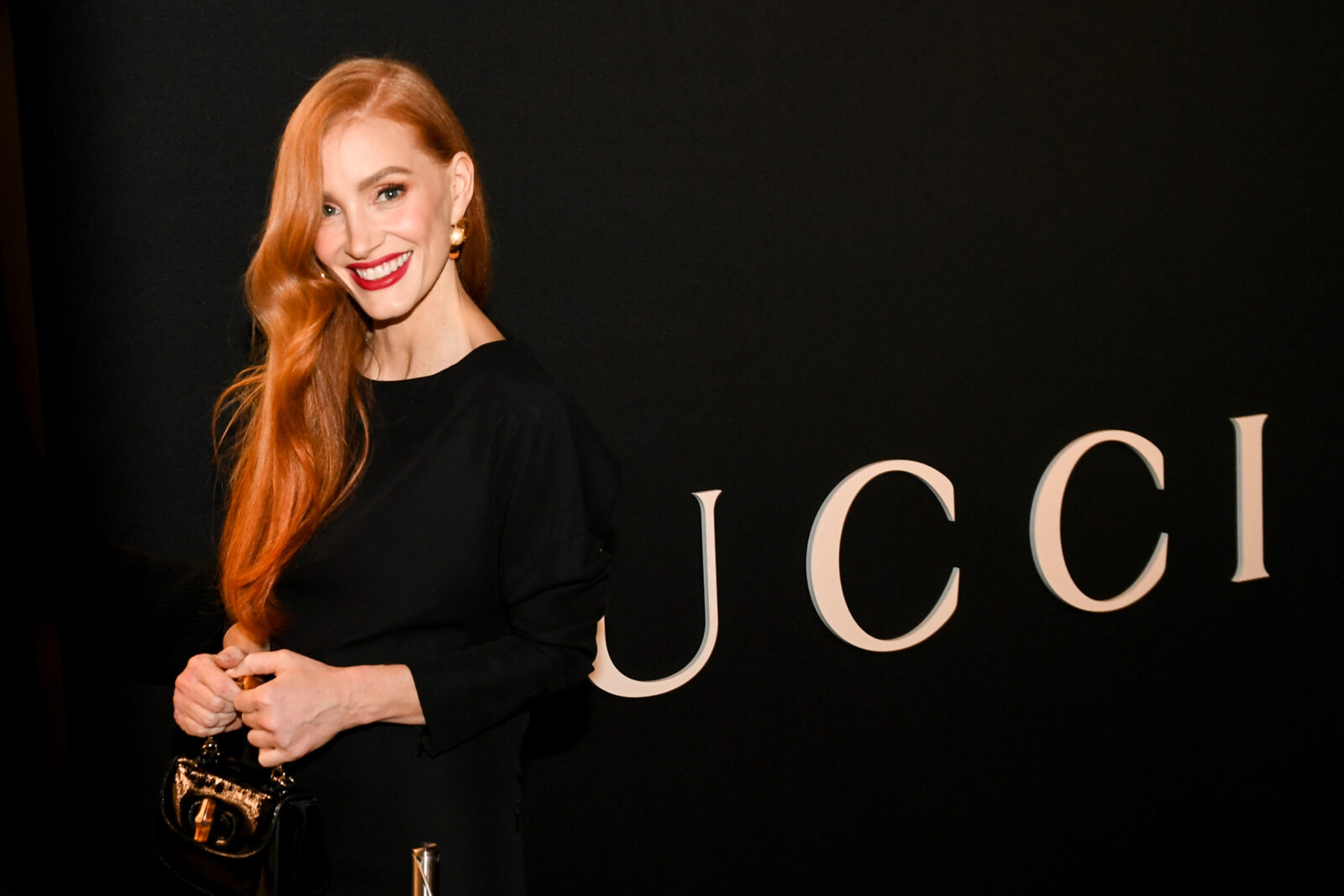 Jessica Chastain strikes a graceful pose, holding a Gucci Bamboo 1947 Super Mini Bag.