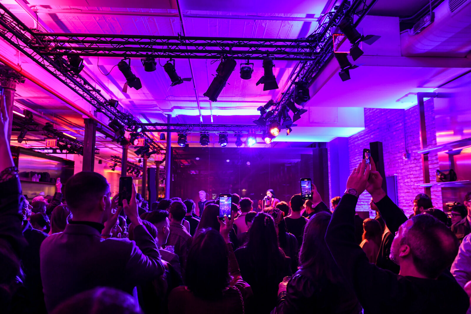 Amidst a luminous setting at Gucci Wooster’s reopening, attendees revel in live music and fashion, capturing the moment with enthralled admiration. Imagery courtesy of BFA.