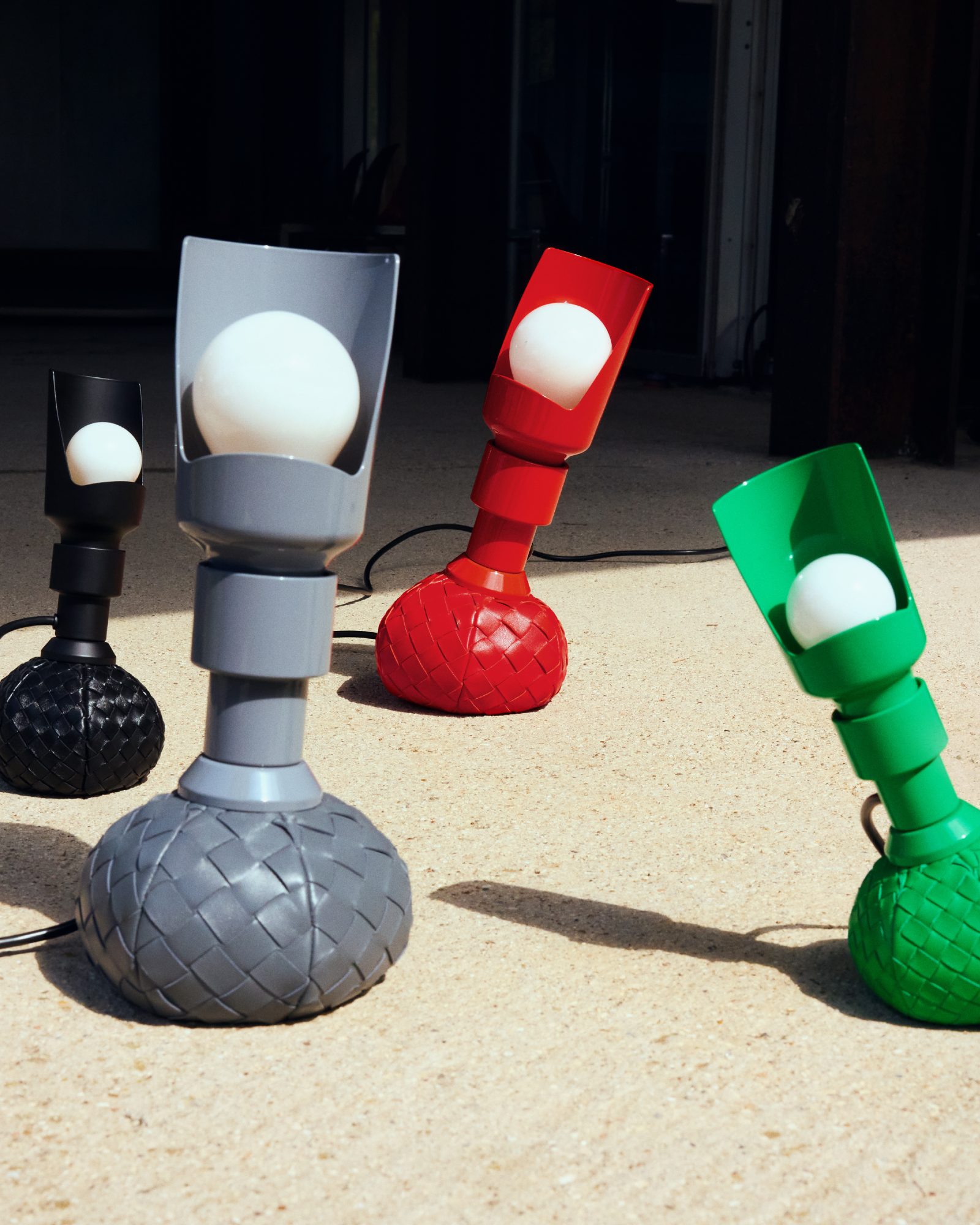 Sarfatti's Model 600 reimagined by Bottega Veneta features intrecciato leather bases in black, grey, red, and signature green. (Image: Courtesy of Bottega Veneta)