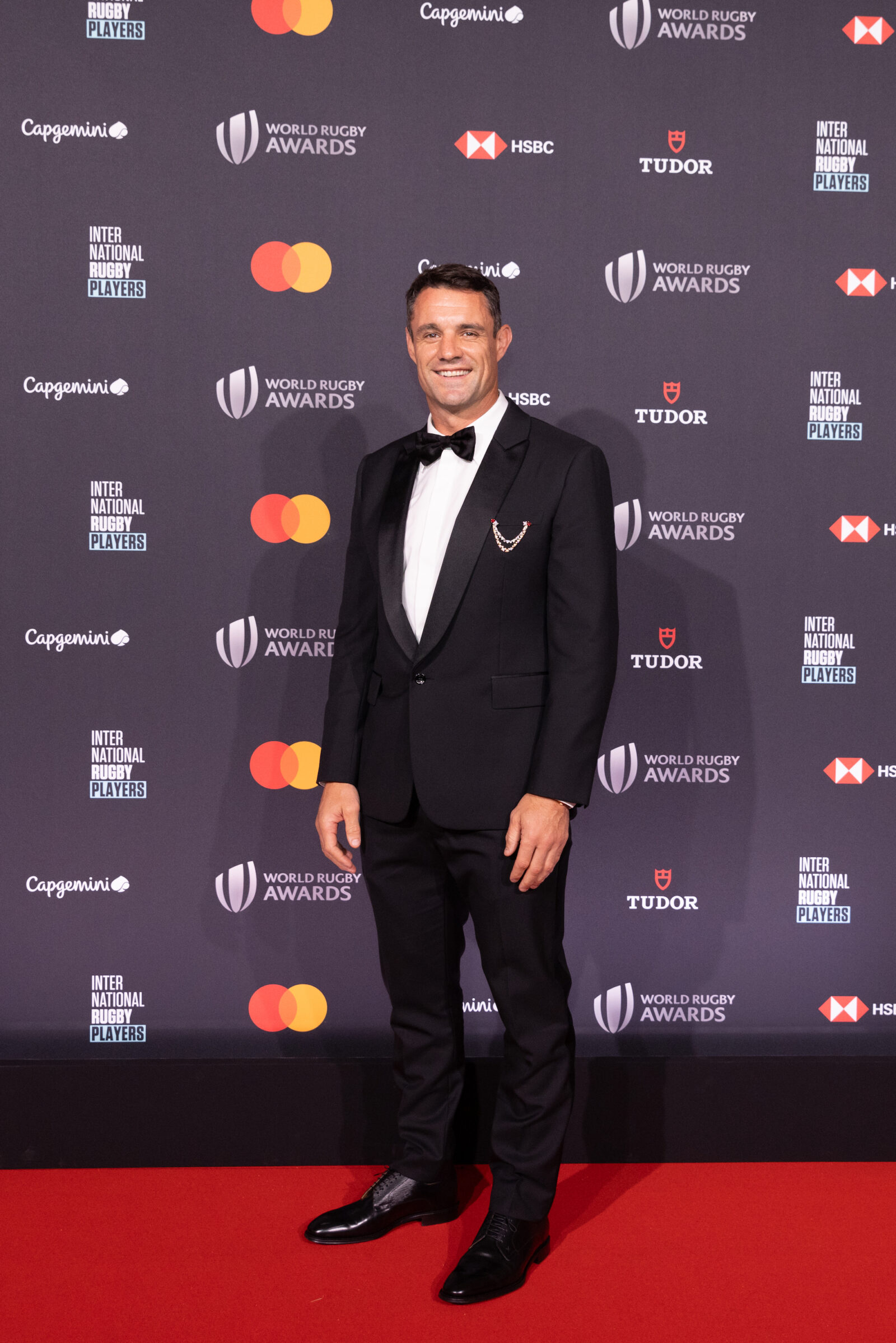 Dan Carter radiantly showcases his Louis Vuitton ensemble, complete with the 18k rose gold Tambour watch and the stunning High Jewelry Spirit brooch, at the 2023 World Rugby Awards. (Photo by Alexis Jacquin for World Rugby/World Rugby via Getty Images)