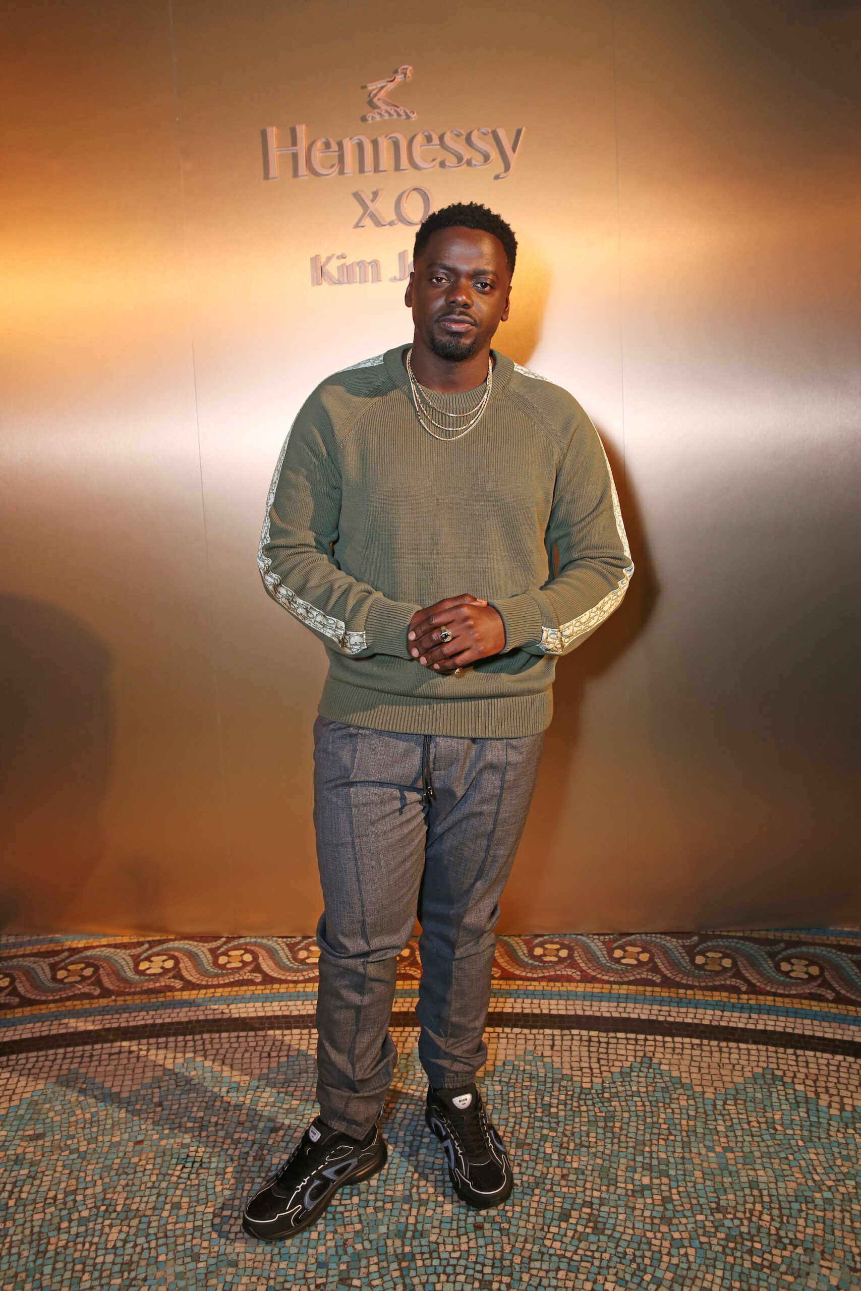 Daniel Kaluuya wore a Dior men’s collection khaki cotton sweater with Dior oblique inserts, a grey wool track pants and black B30 sneakers. Daniel Kaluuya