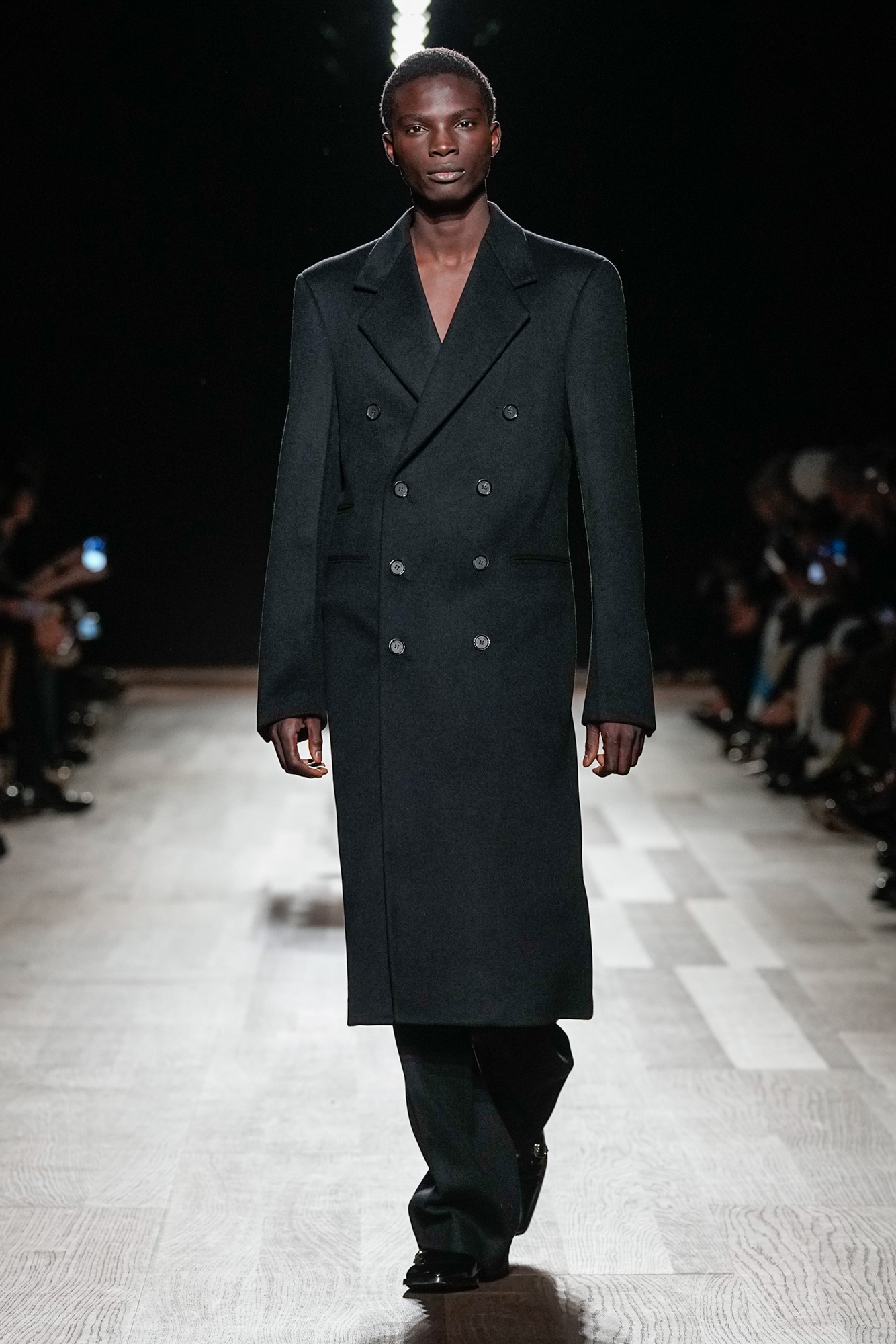 Look 12 | Ferragamo Fall-Winter 2024 runway presentation showcasing the black wool-cashmere double-breasted long coat with architectural shoulders and straight silhouette, paired with wide-leg trousers. (Photo: Courtesy of Ferragamo)