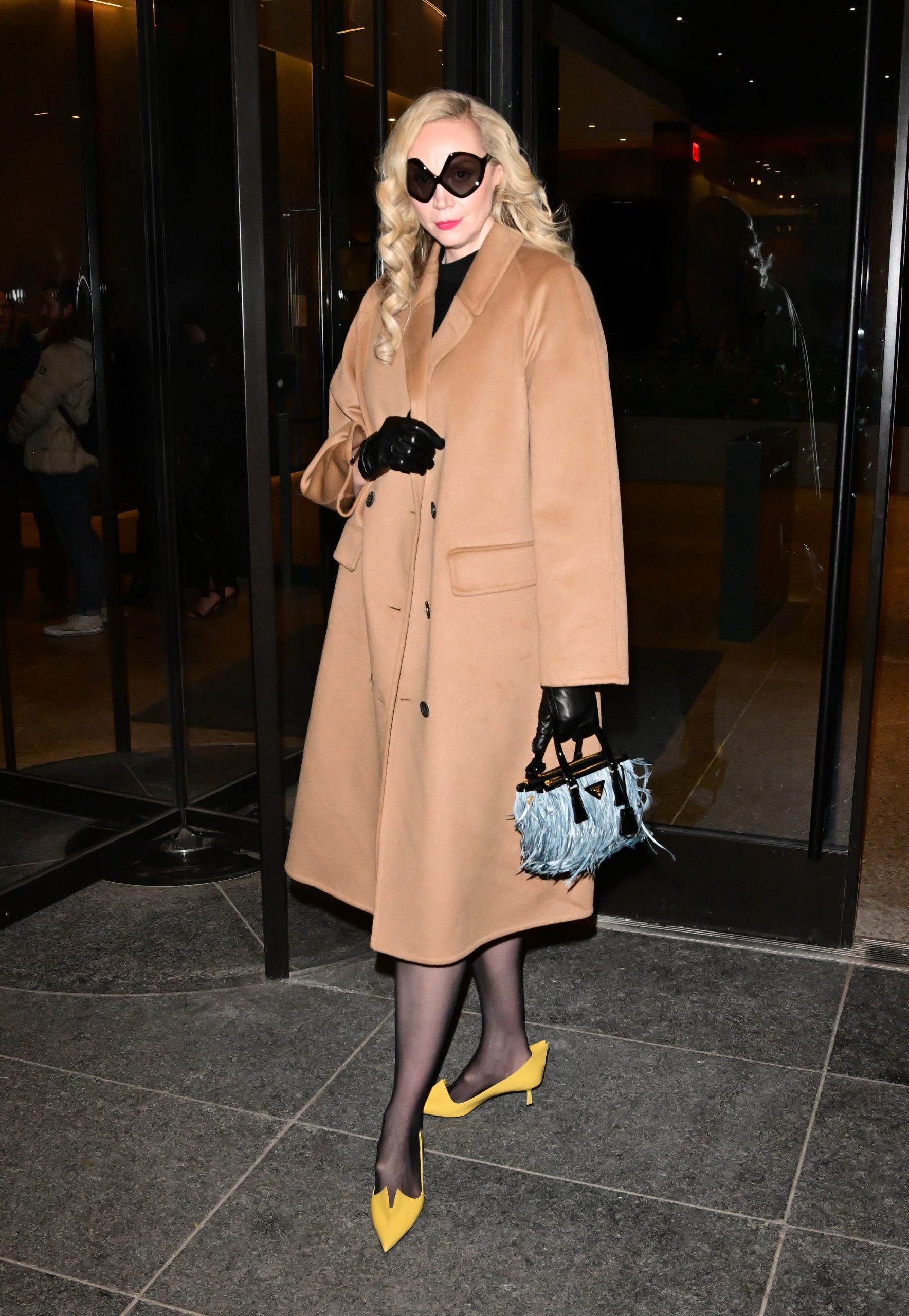 Gwendoline Christie appears in a camel Prada coat, paired with yellow kitten heels and a feathered handbag while out in New York City on January 15, 2025. (Photo by Christopher Peterson/SplashNews.com)