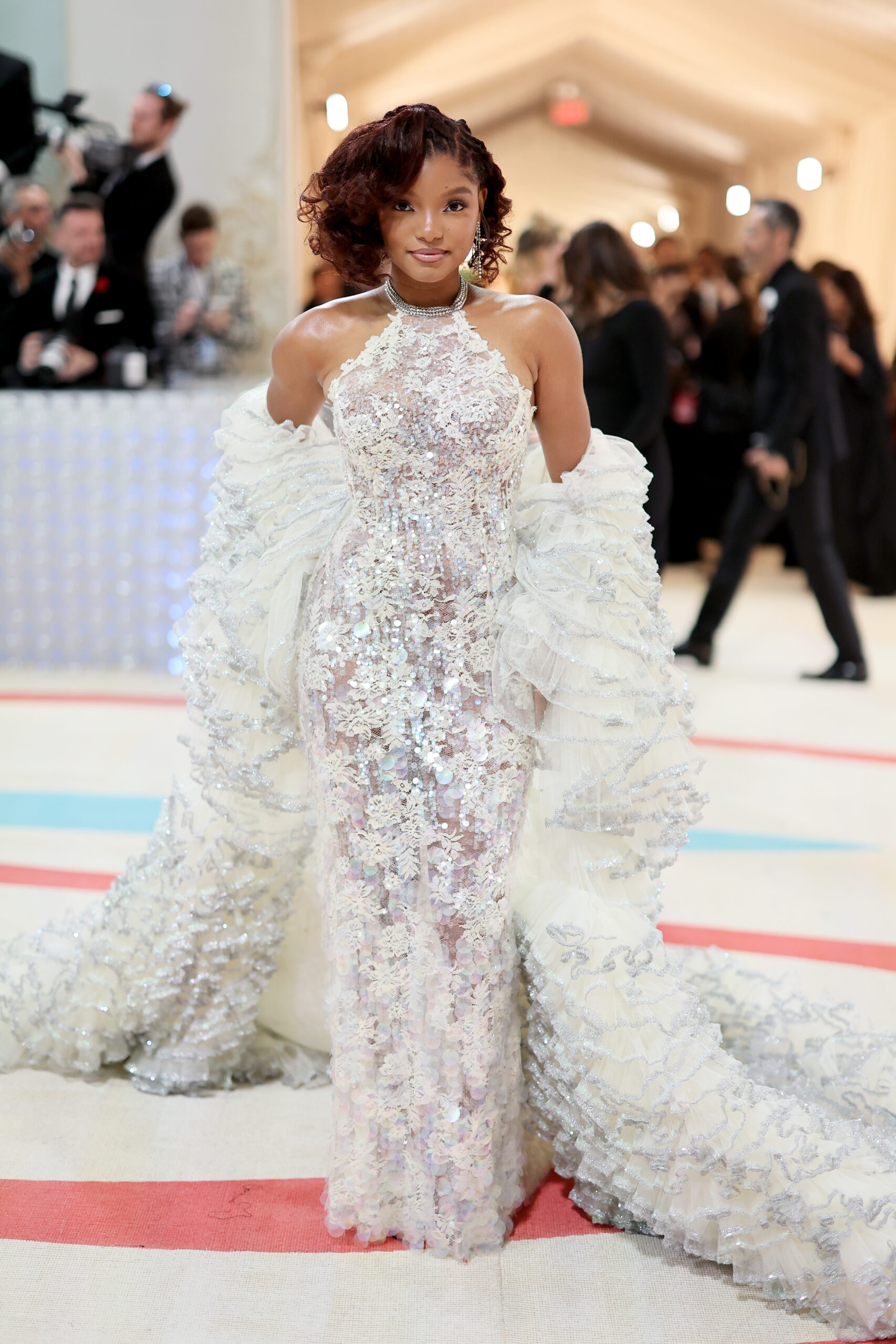 Halle Bailey wore a custom white lace sequin-embroidered gown with a ruffle coat Halle Bailey