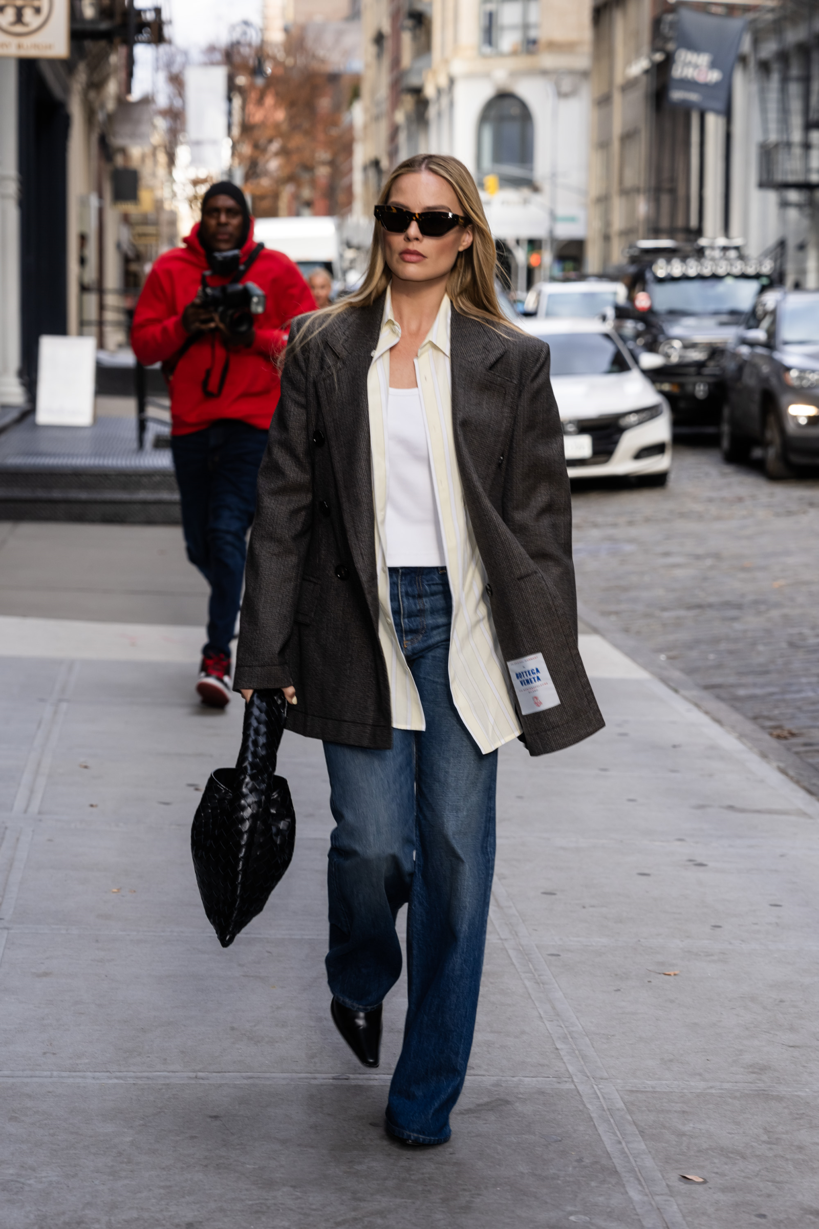 Effortless elegance: Margot Robbie takes on NYC in Bottega Veneta’s signature houndstooth wool jacket and chic flared denim. A masterclass in timeless style. Photo courtesy of Bottega Veneta.