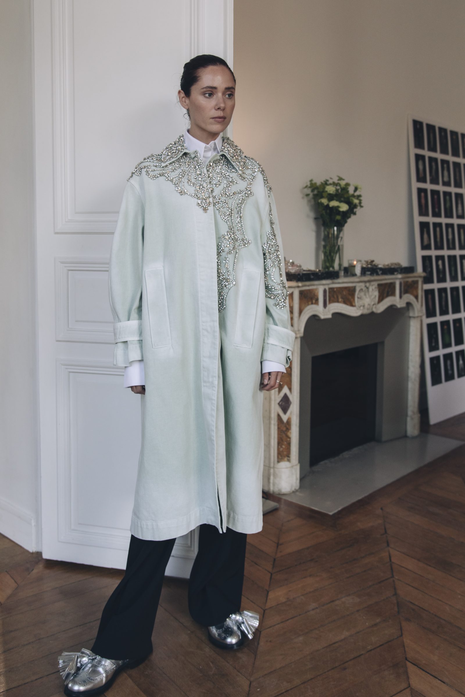 A model showcases the intricate embroidery on a lightweight spring coat, completing the look are metallic loafers with exaggerated tassels (Image: Tonya Matyu).