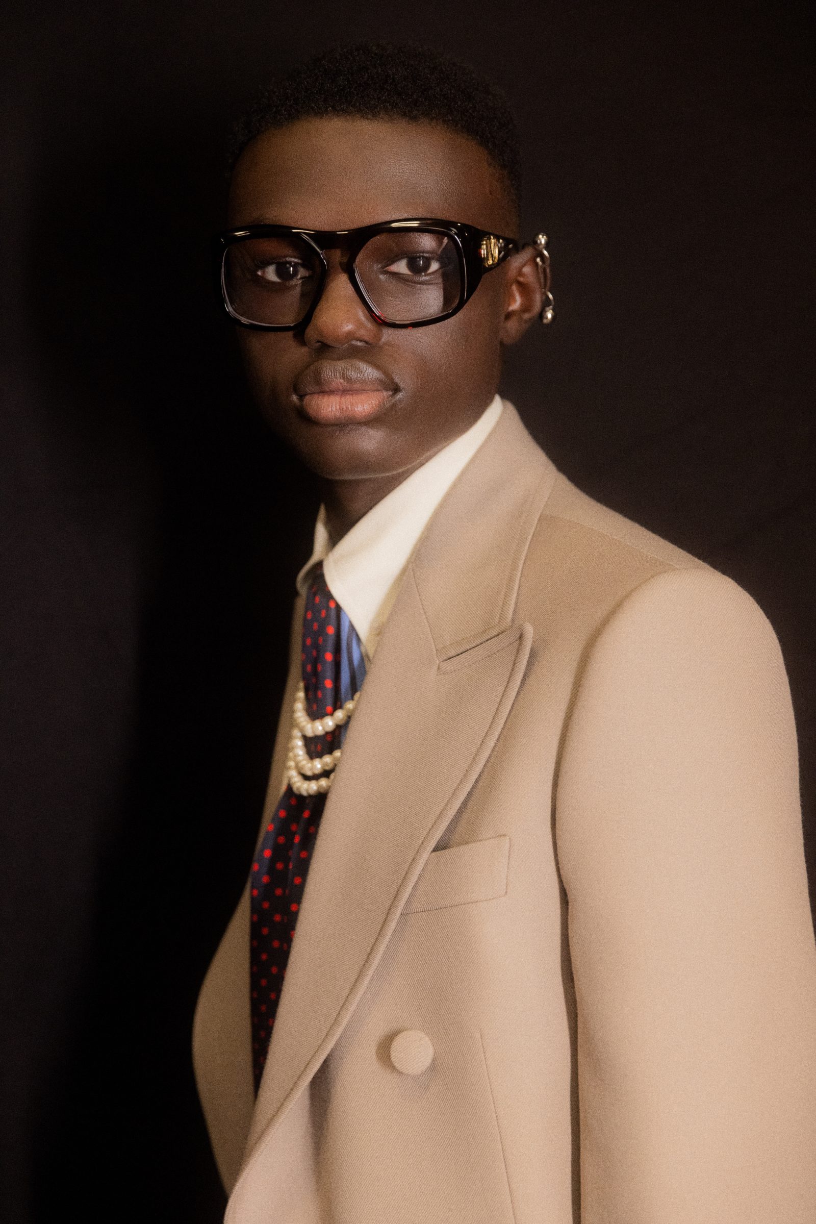 Close-up of model in chunky black Valentino optical frames with gold VLogo detail (Image: Kevin Tachman)