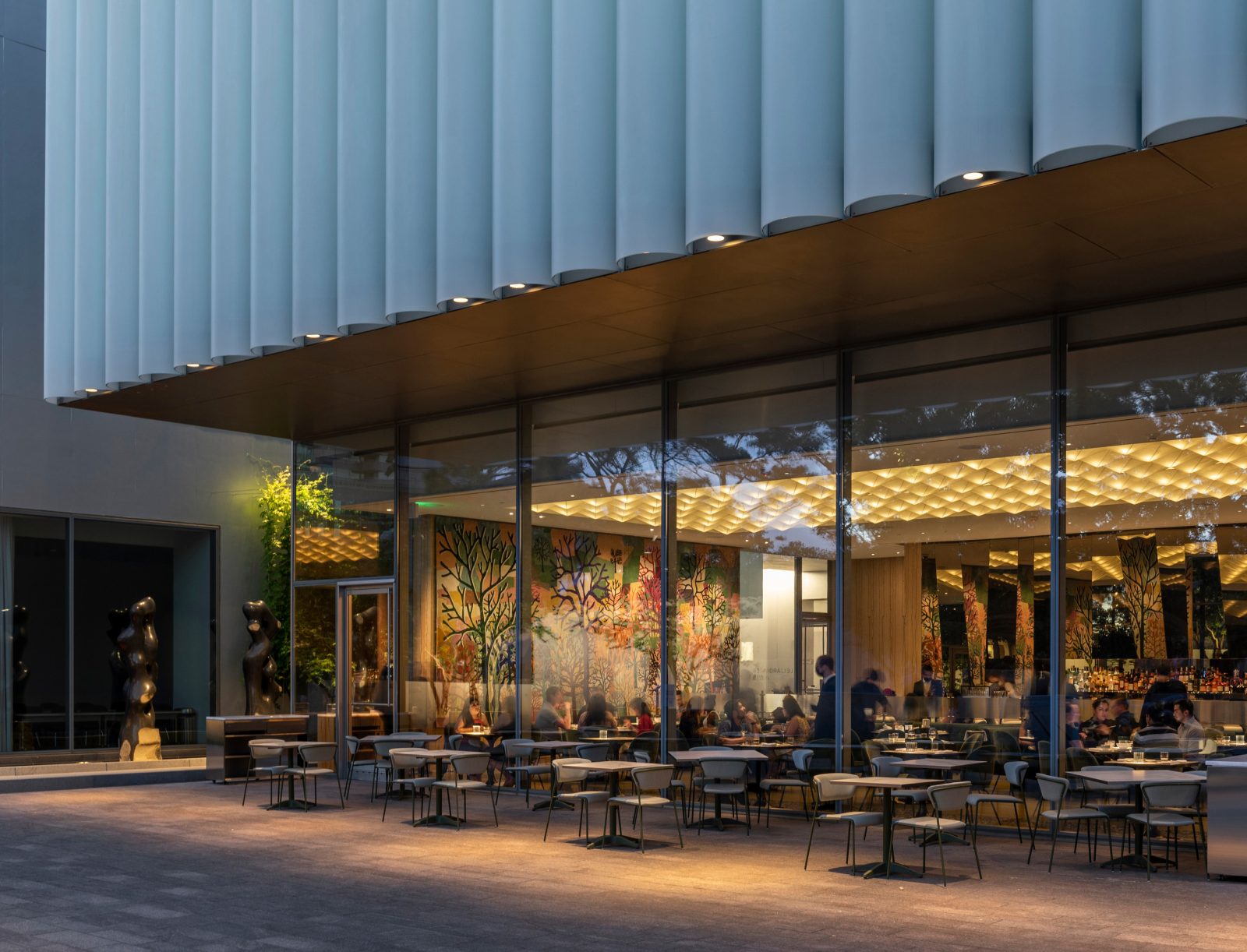 The architectural elements of the Nancy and Rich Kinder Building complement the Isamu Noguchi-designed Cullen Sculpture Garden, visible through the illuminated glass façade. (Photo: Julie Soefer)