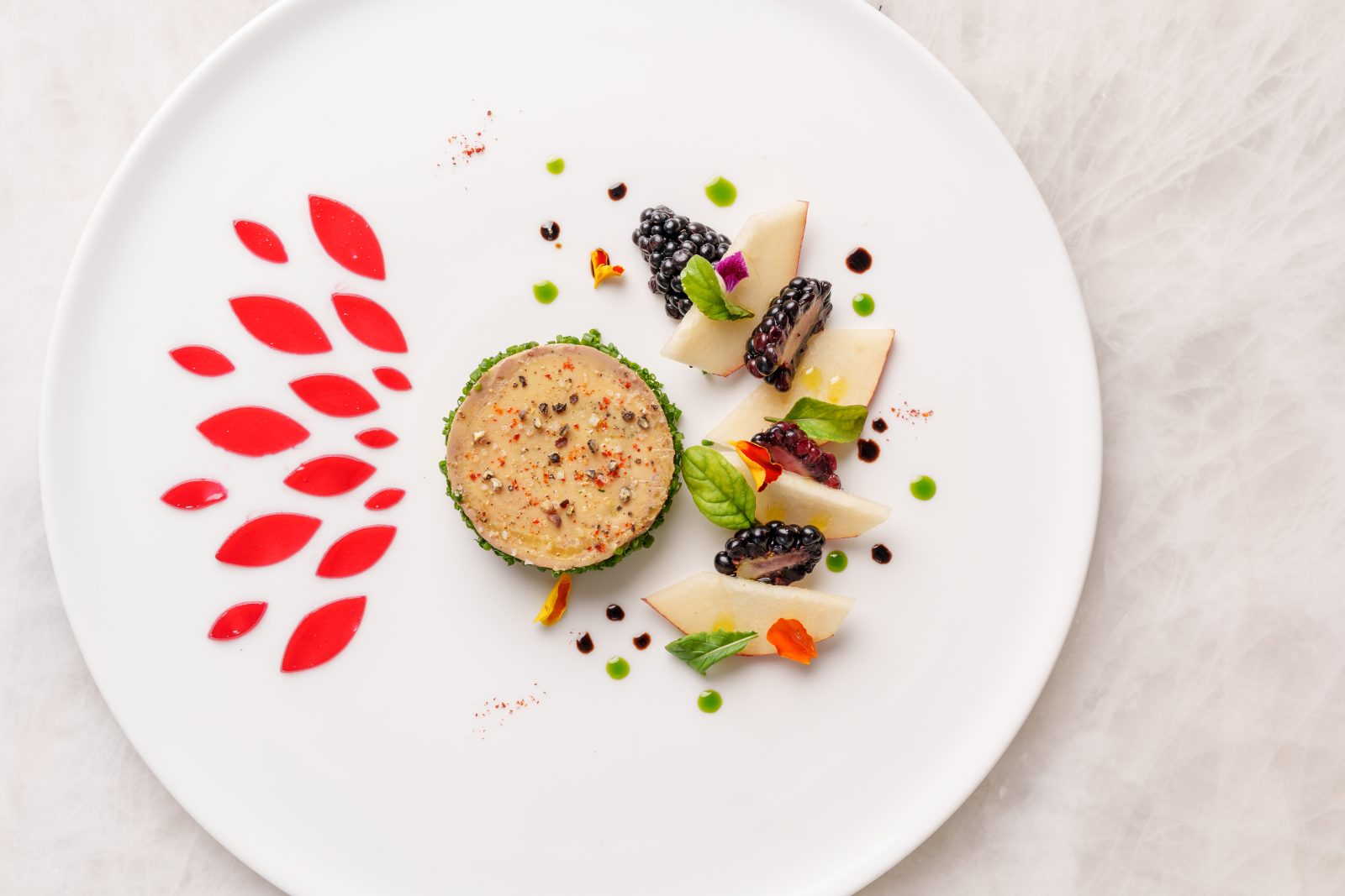 A terrine, garnished with blackberries, micro herbs, and a striking red geometric sauce, mirrors the museum's artistic sensibilities.
