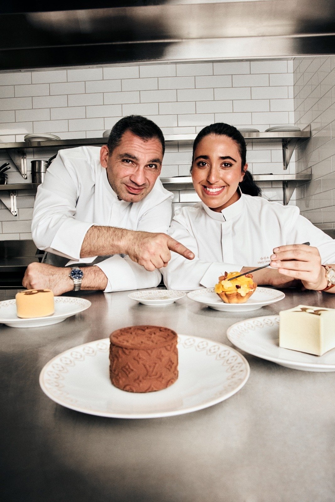 Chefs Christophe Bellanca and Mary George present a signature monogram-embossed chocolate creation at Le Café Louis Vuitton, blending French pastry artistry with the House’s luxury codes.
