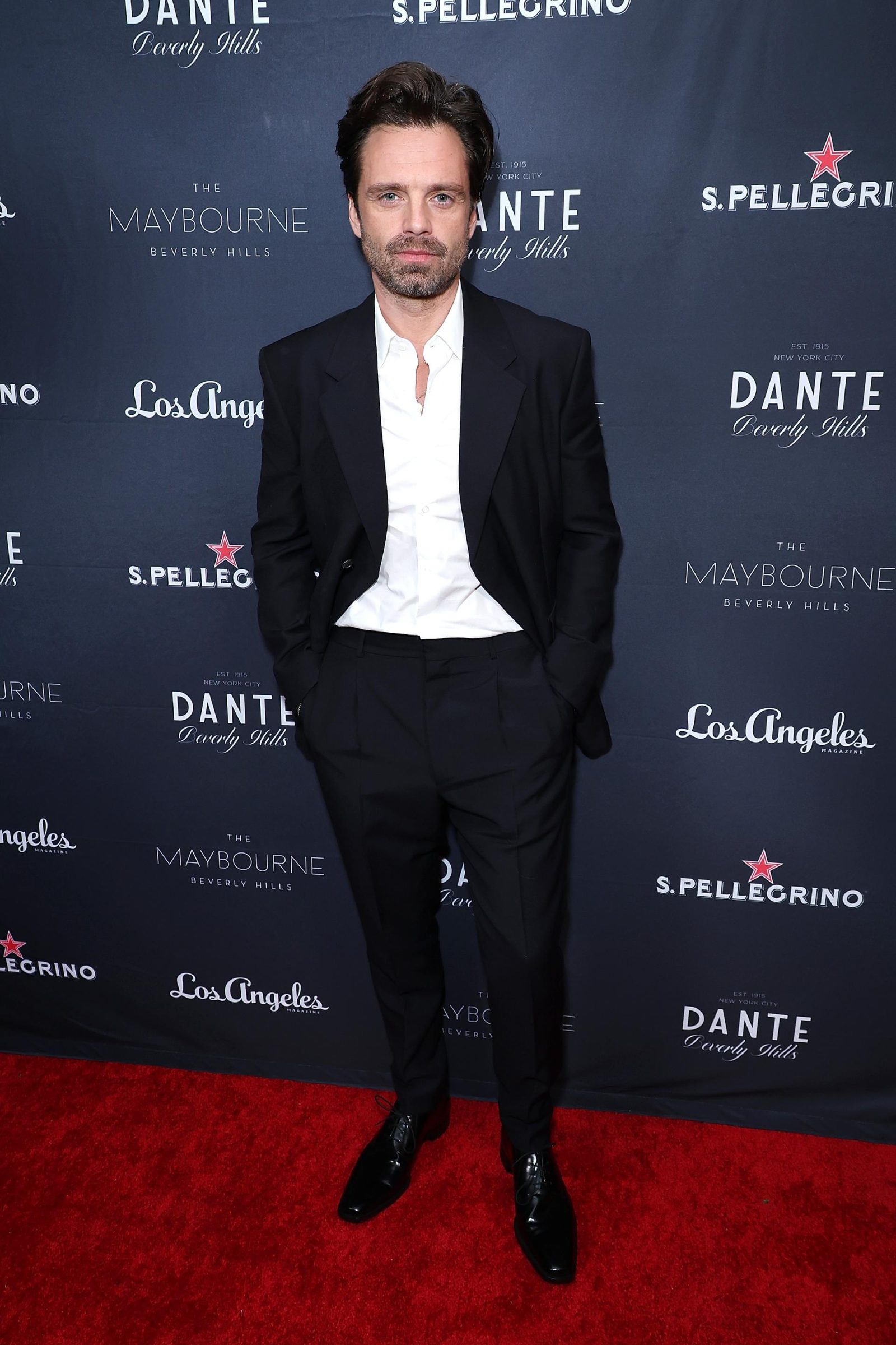 Stan opts for timeless elegance in a black suit and white collarless shirt at The Maybourne Opening. (Photo: Courtesy of Prada)