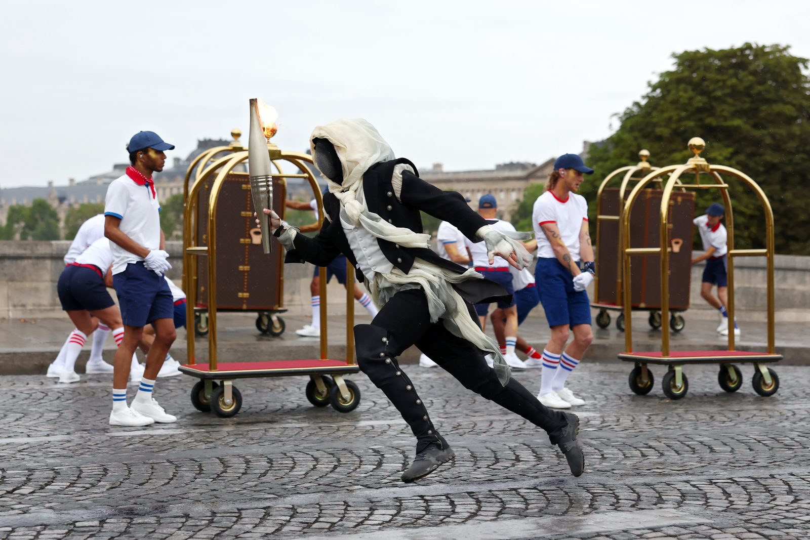 A torchbearer runs past Pont Neuf during the opening ceremony of the Olympic Games Paris 2024 on July 26, 2024 in Paris, France. (Photo by Maddie Meyer/Getty Images)