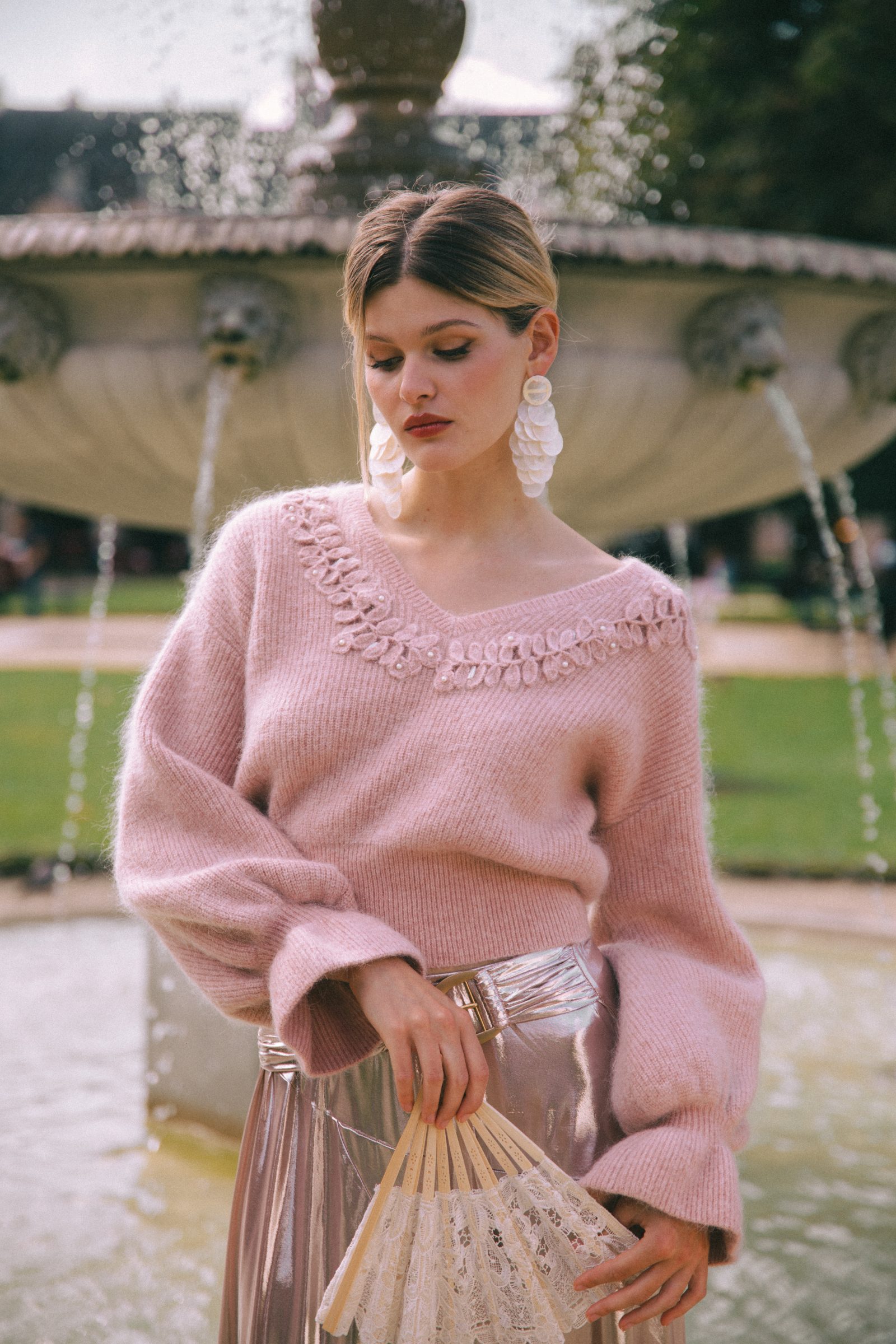 Romance meets whimsy: A rose-pink mohair sweater with loop-trimmed neckline paired with a metallic pleated skirt, from Phème Paris' Winter 2024 collection (Image: Phème Paris)