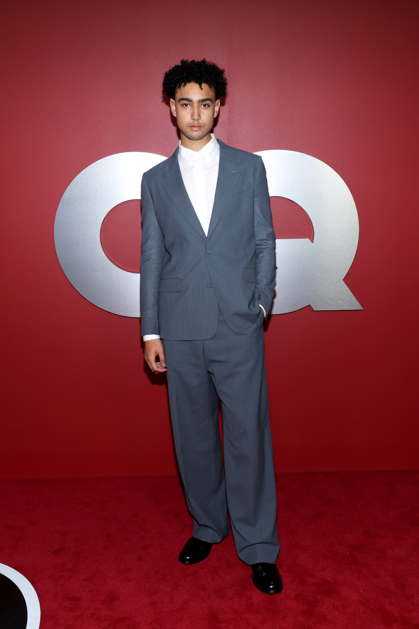 Archie Madekwe cuts a dapper figure in a tailored Dior grey wool suit and classic leather derbies at the GQ Men of the Year event. (Photo by Phillip Faraone/Getty Images for GQ)