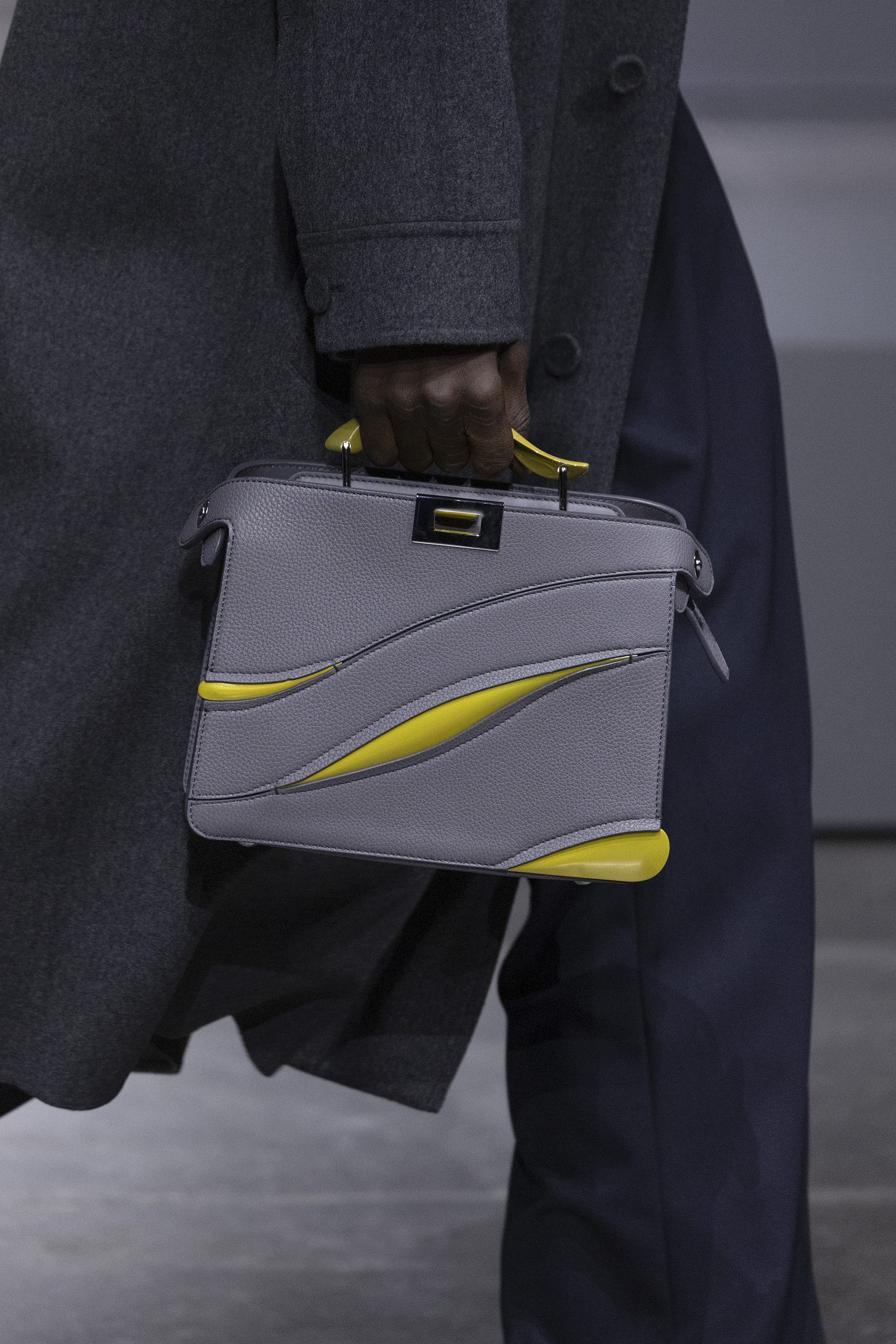 The MAD x FENDI Small Peekaboo ISeeU, offered in yellow and aluminum grey, is seen on the runway.