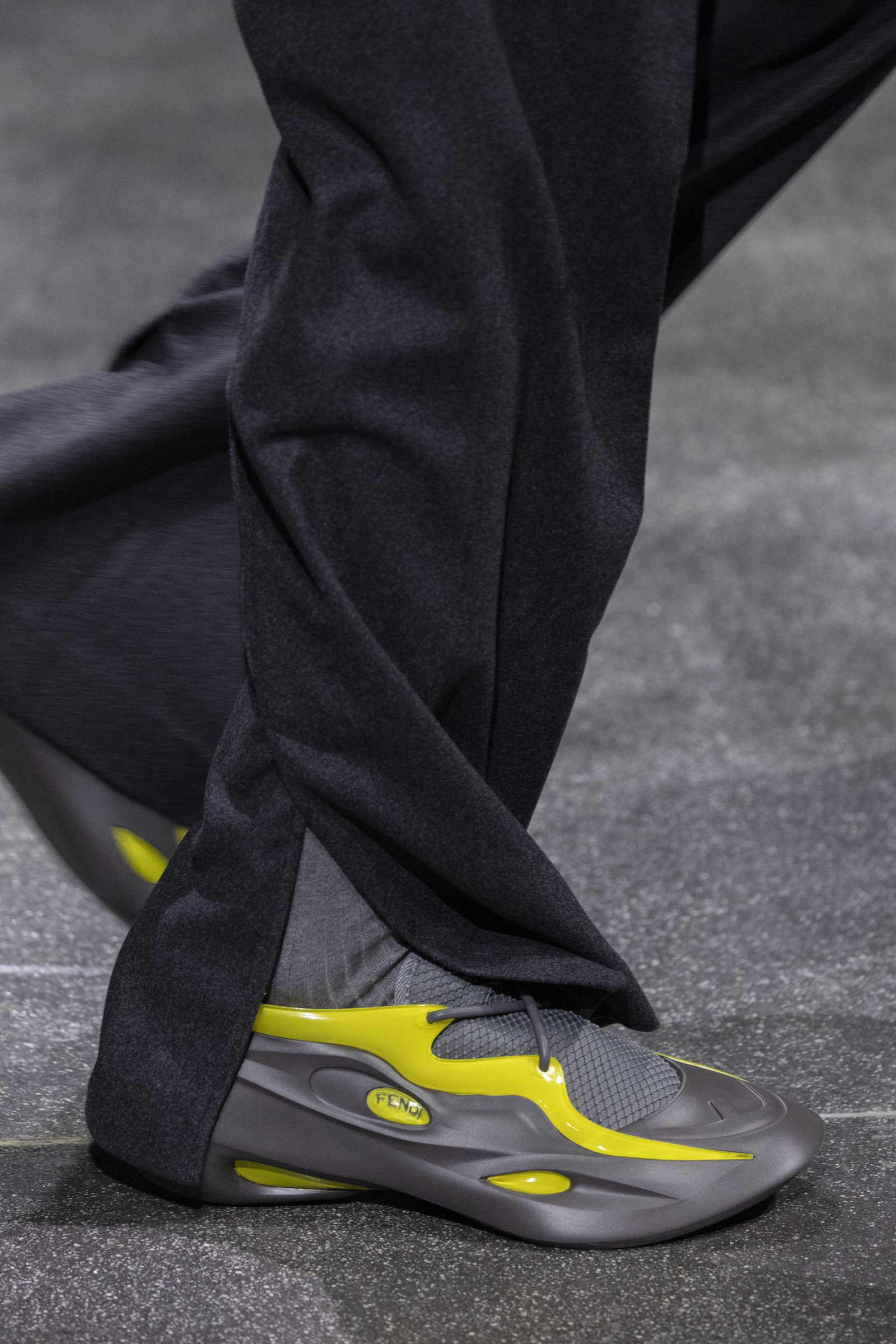 The matching FENDI MAD sneakers in yellow/aluminum grey are seen on the runway.
