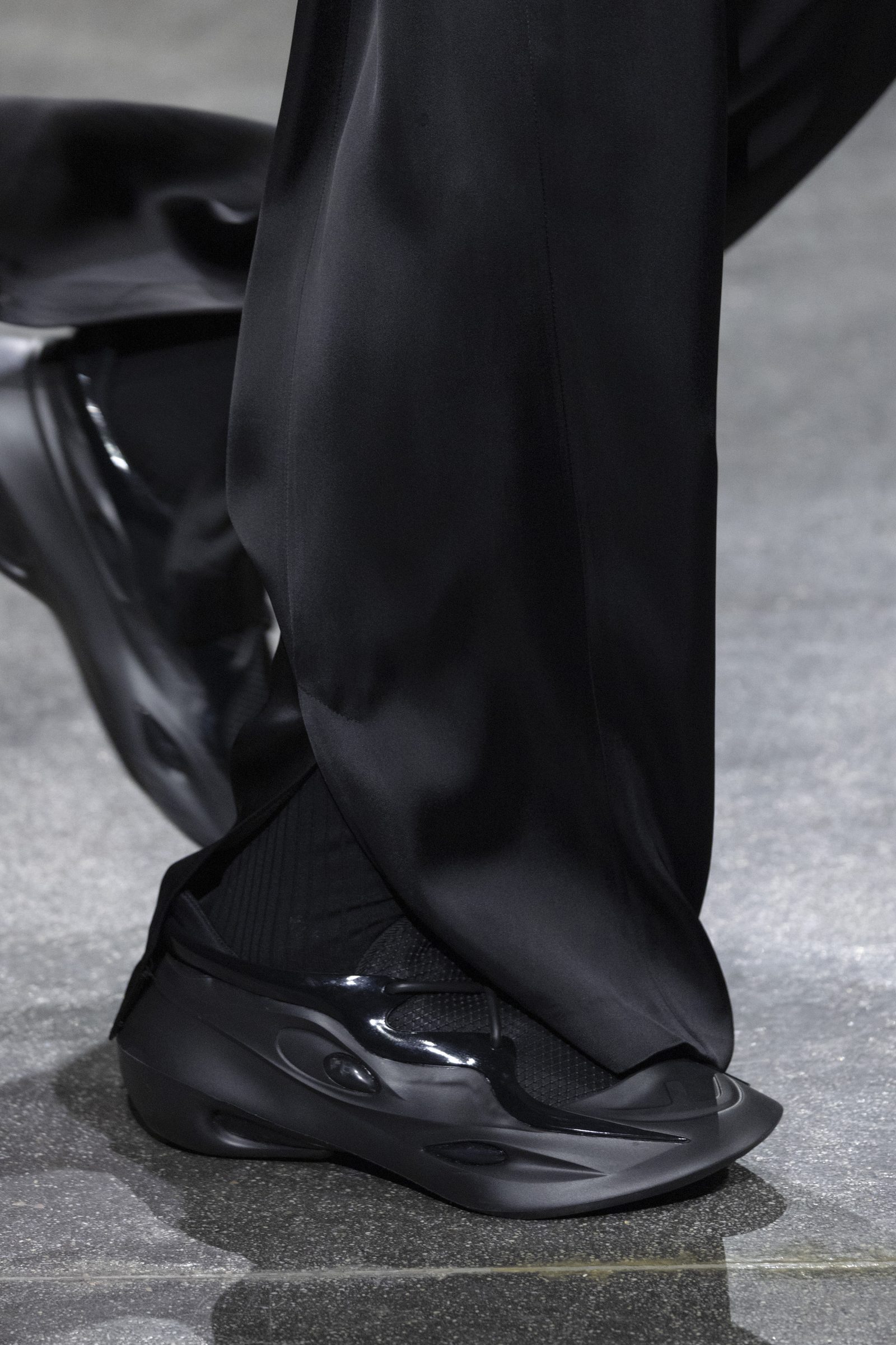 The matching FENDI MAD sneakers in black are seen on the runway.