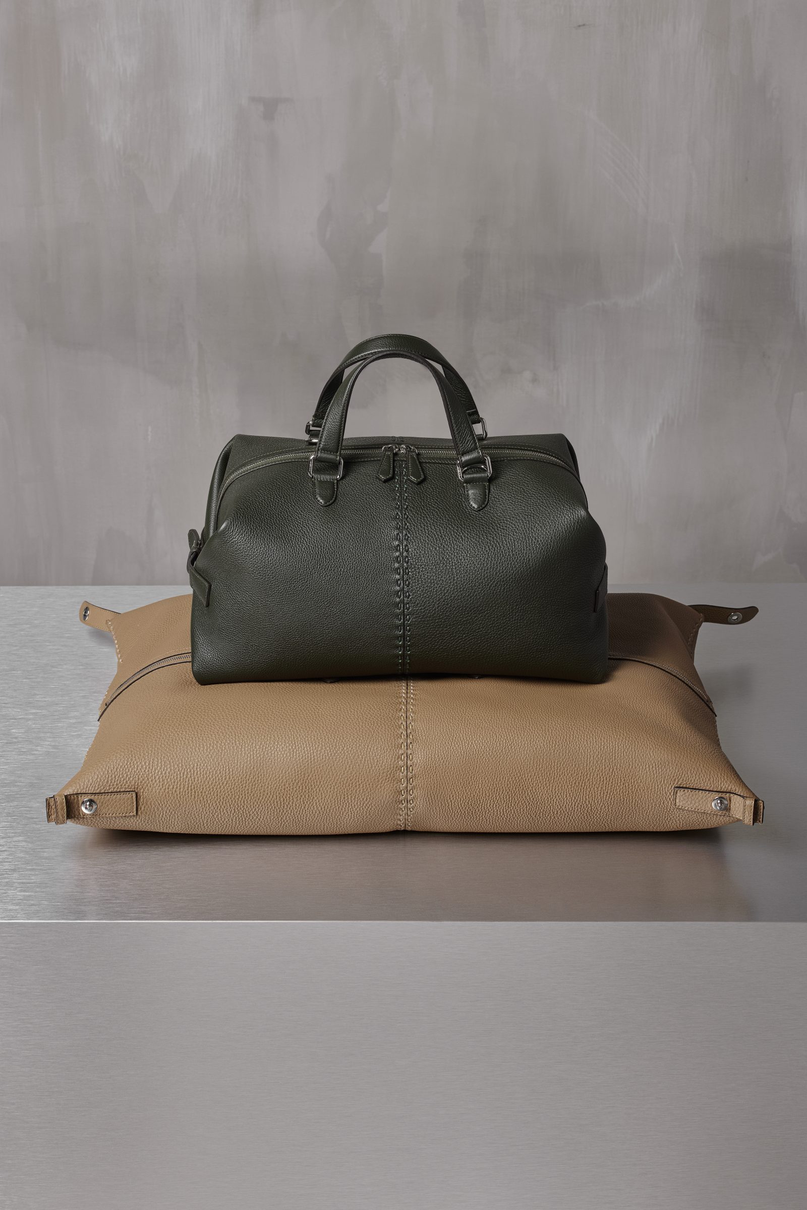 The FENDI Siesta Medium bag in dark green and beige highlighting its two iterations of shape and utility transformation.