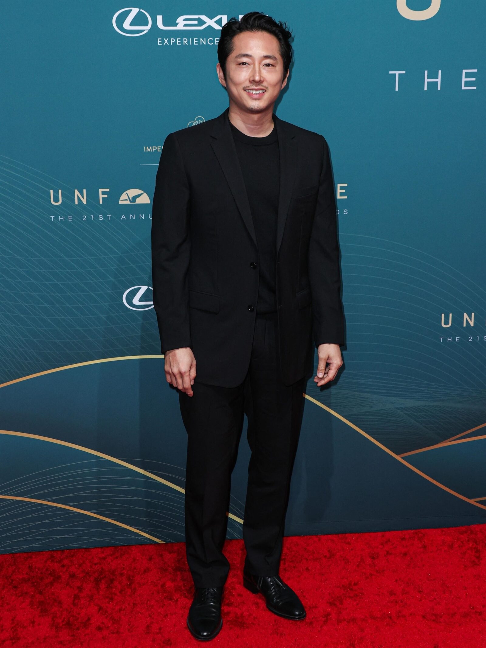 Red Carpet Sophistication: Steven Yeun exemplifies the timeless charm of Dior at the 21st Annual Unforgettable Gala.