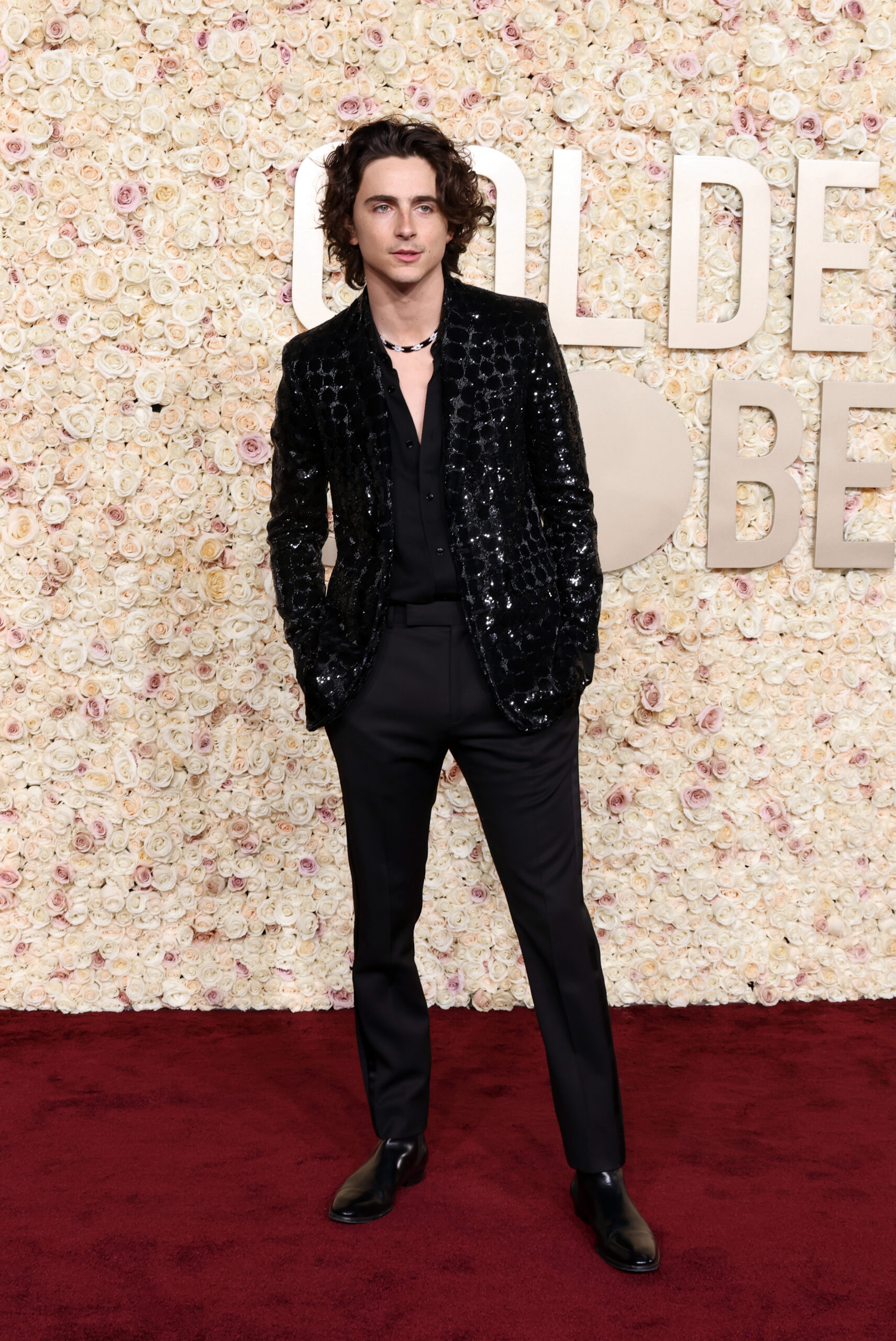 Full-length view of Timothée Chalamet on the Golden Globes red carpet, showcasing his CELINE HOMME ensemble with sleek Chelsea boots. (Photo by Amy Sussman/Getty Images, courtesy of CELINE)