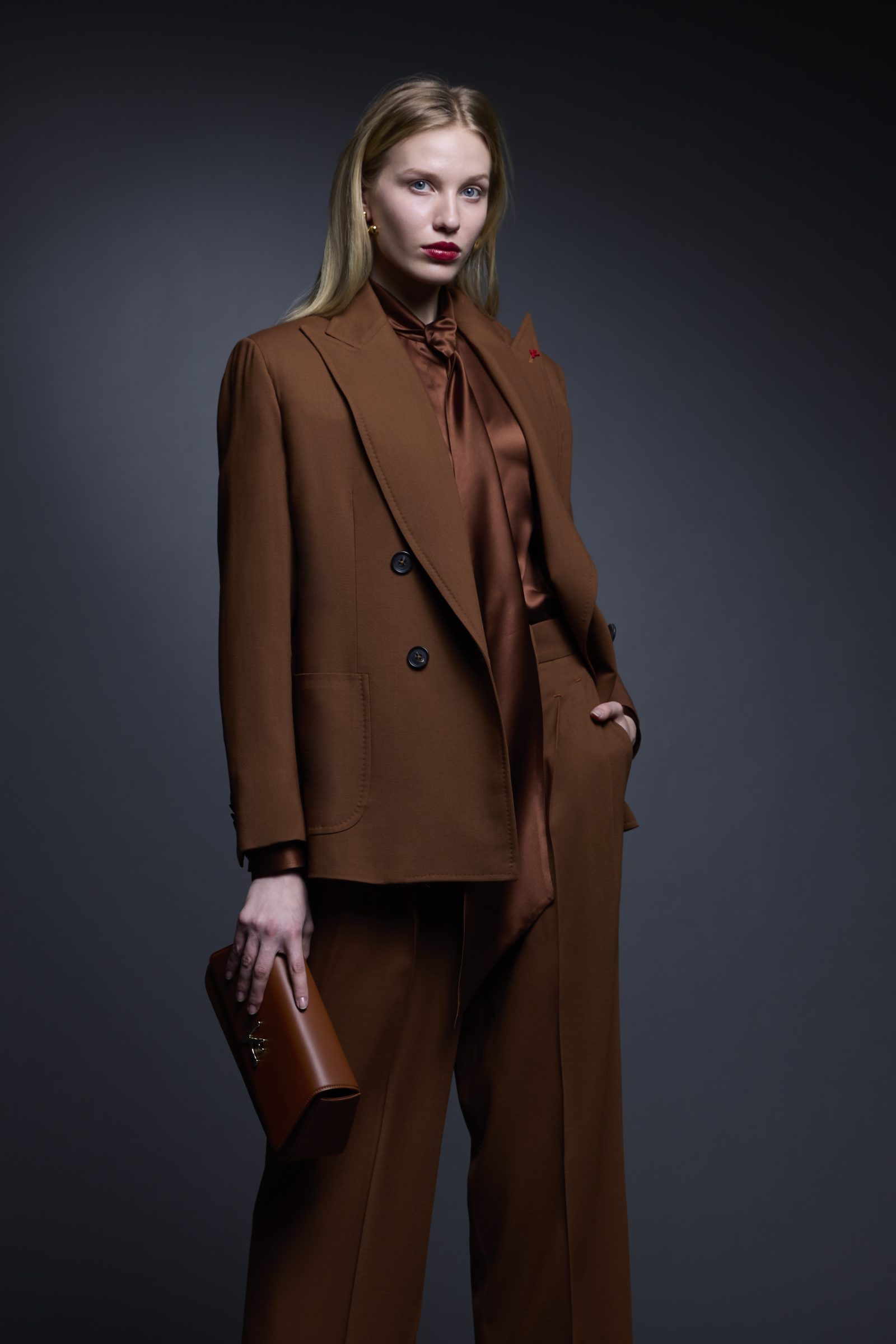 A precisely tailored tobacco suit with fluid trousers and matching silk tie-neck blouse showcases ISAIA's womenswear debut. (Image: Courtesy of ISAIA)