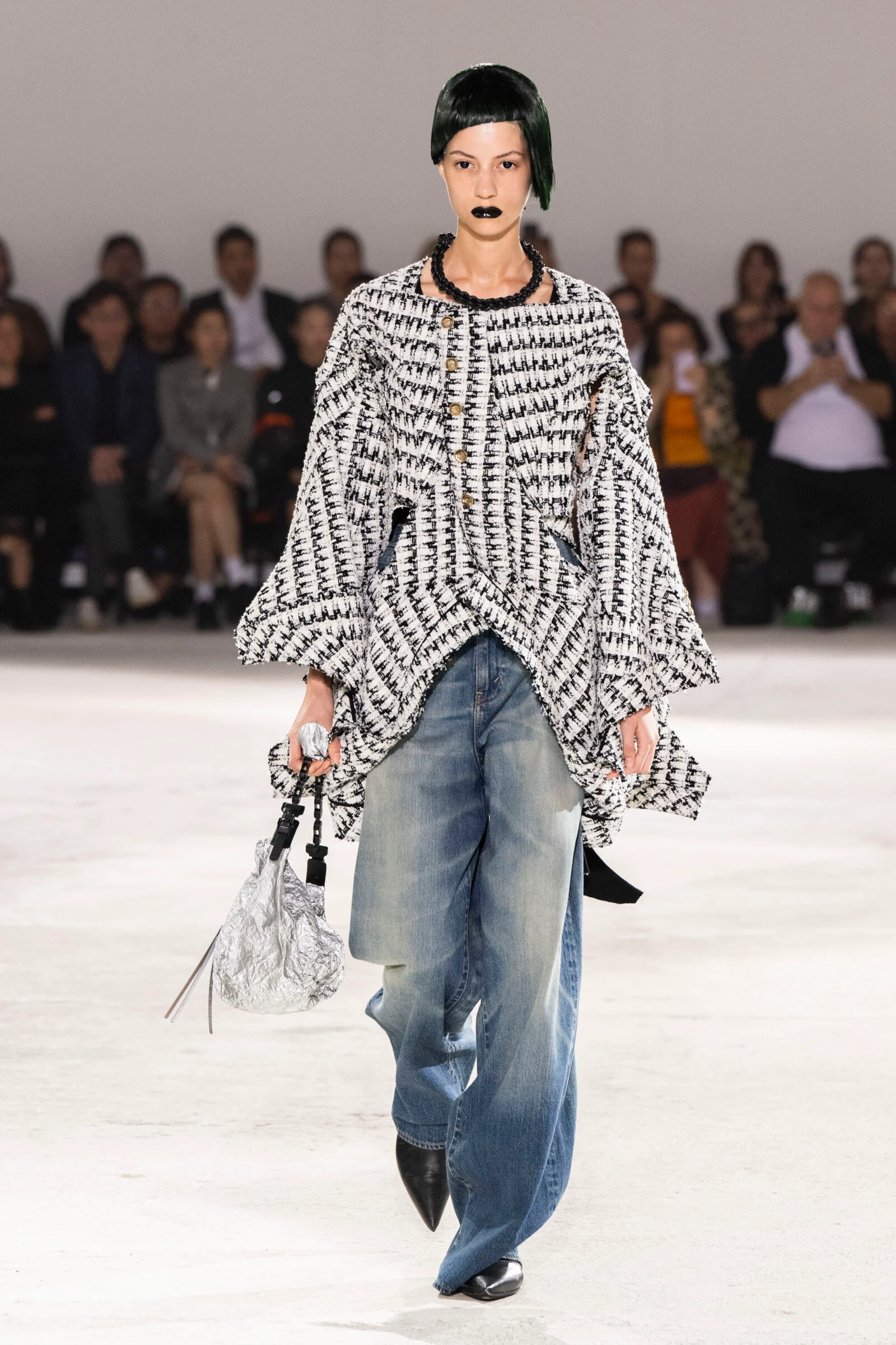 A Junya Watanabe look reimagines the iconography of Chanel's classic tweed, blending tradition with a forward-looking fashion narrative.