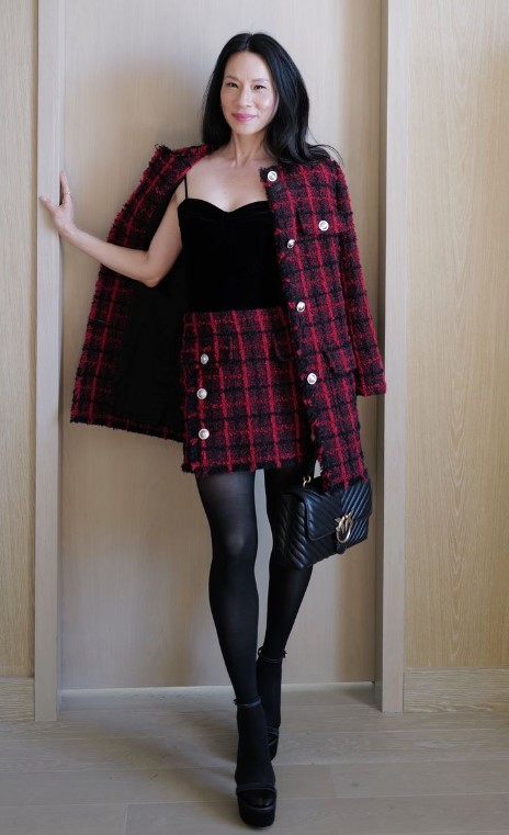 Lucy Liu stuns in a red-and-black checked Versace tweed ensemble, featuring a structured cardigan coat with Medusa buttons and a coordinating mini skirt. (Photo Credit: IG @sarahslutsky)