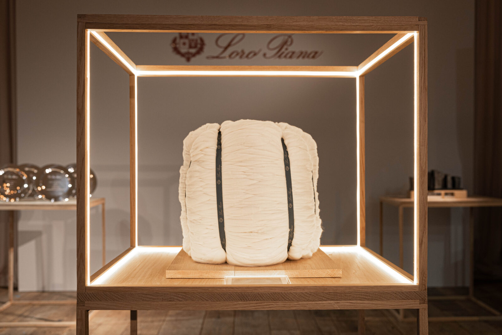 Illuminated Legacy: The World Record Bale of Merino wool, enshrined in a luminous display, stands as a beacon of Loro Piana's commitment to unparalleled quality and craftsmanship in the world of luxury textiles.