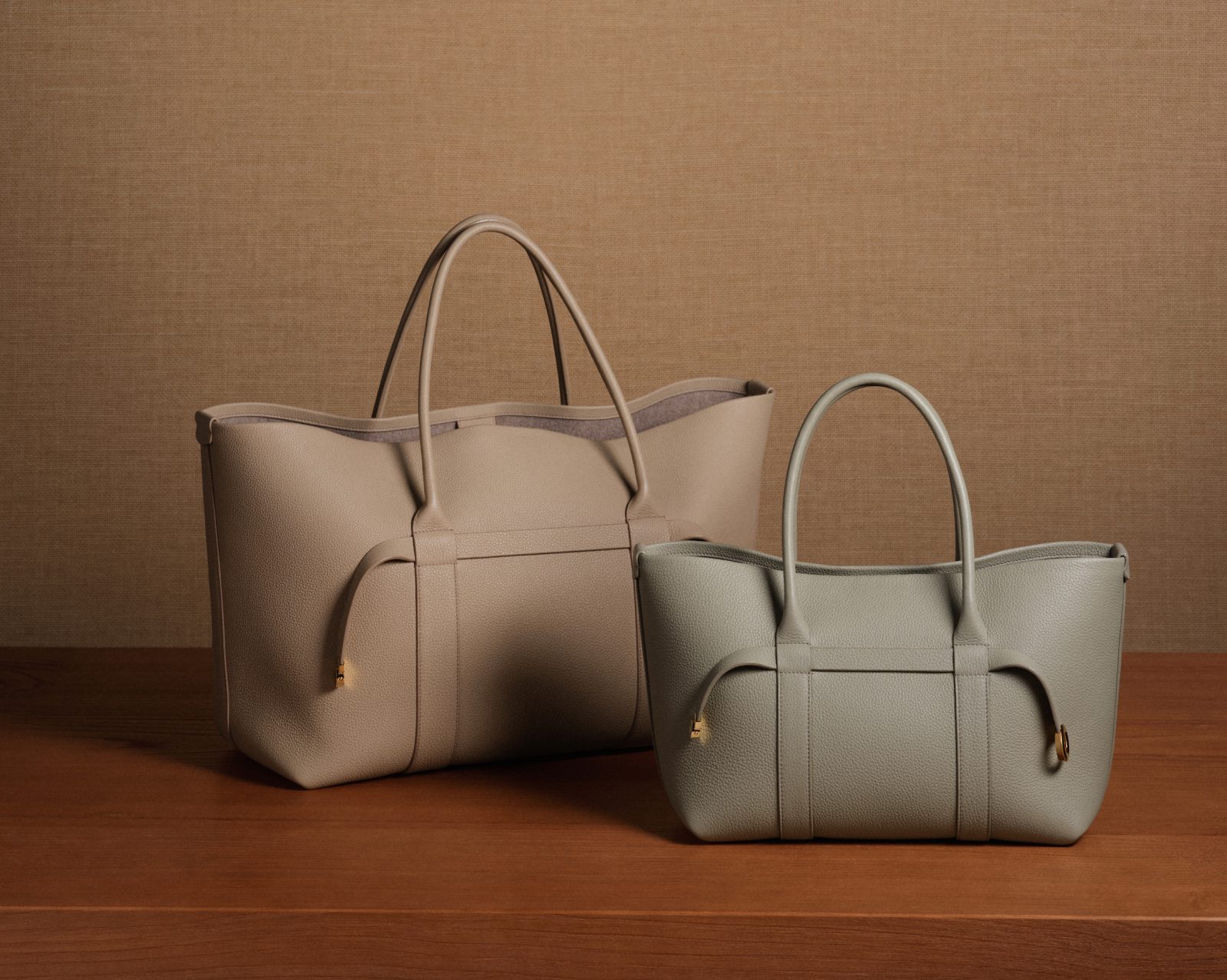 The Ghiera Shopper in two sizes, crafted in grained leather in Fossil and Light Travertine