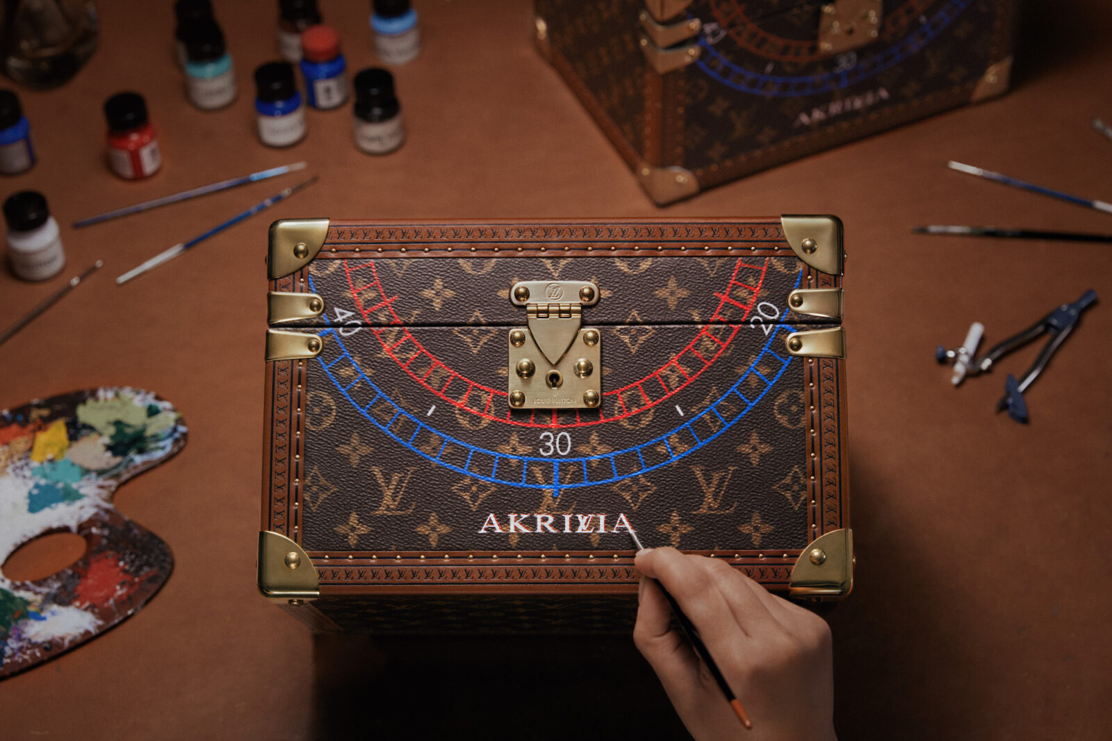 A finishing touch as the Louis Vuitton signature 'LV' into the 'Akrivia' lettering is painted on the bespoke trunk for the LVRR-01 watch.