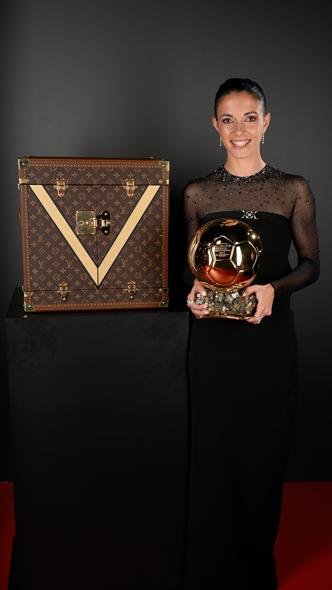 Aitana Bonmatí, radiant beside the Louis Vuitton case, wearing a dress as dazzling as her year in football. Aitana Bonmatí, radiant beside the Louis Vuitton case, wearing a dress as dazzling as her year in football.