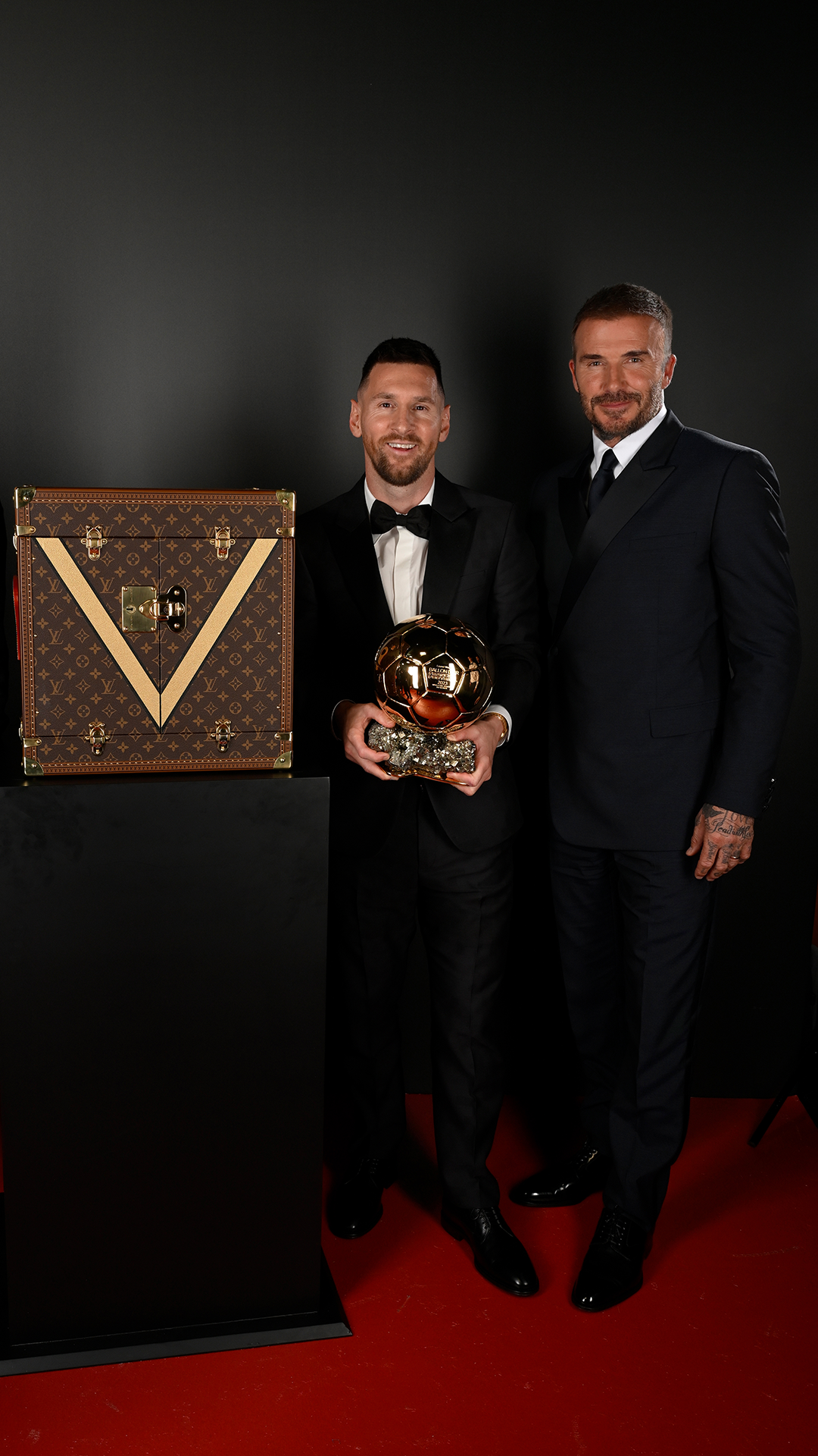 Football legends meet luxury: Lionel Messi and David Beckham Stars shine alongside the signature Louis Vuitton Ballon d'Or case.