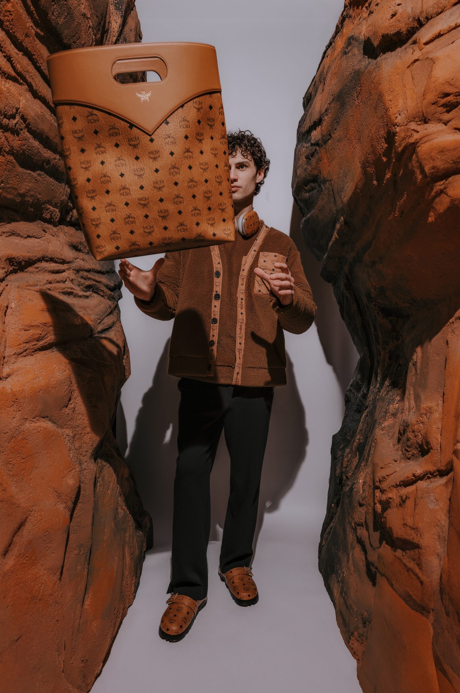 A model showcases the new MIRUM® Ready-to-Wear collection, pairing it with novel MCM Monogrammed Moccasins and effortlessly toting a new soft-shaped bag crafted from plant-based leather alternatives.